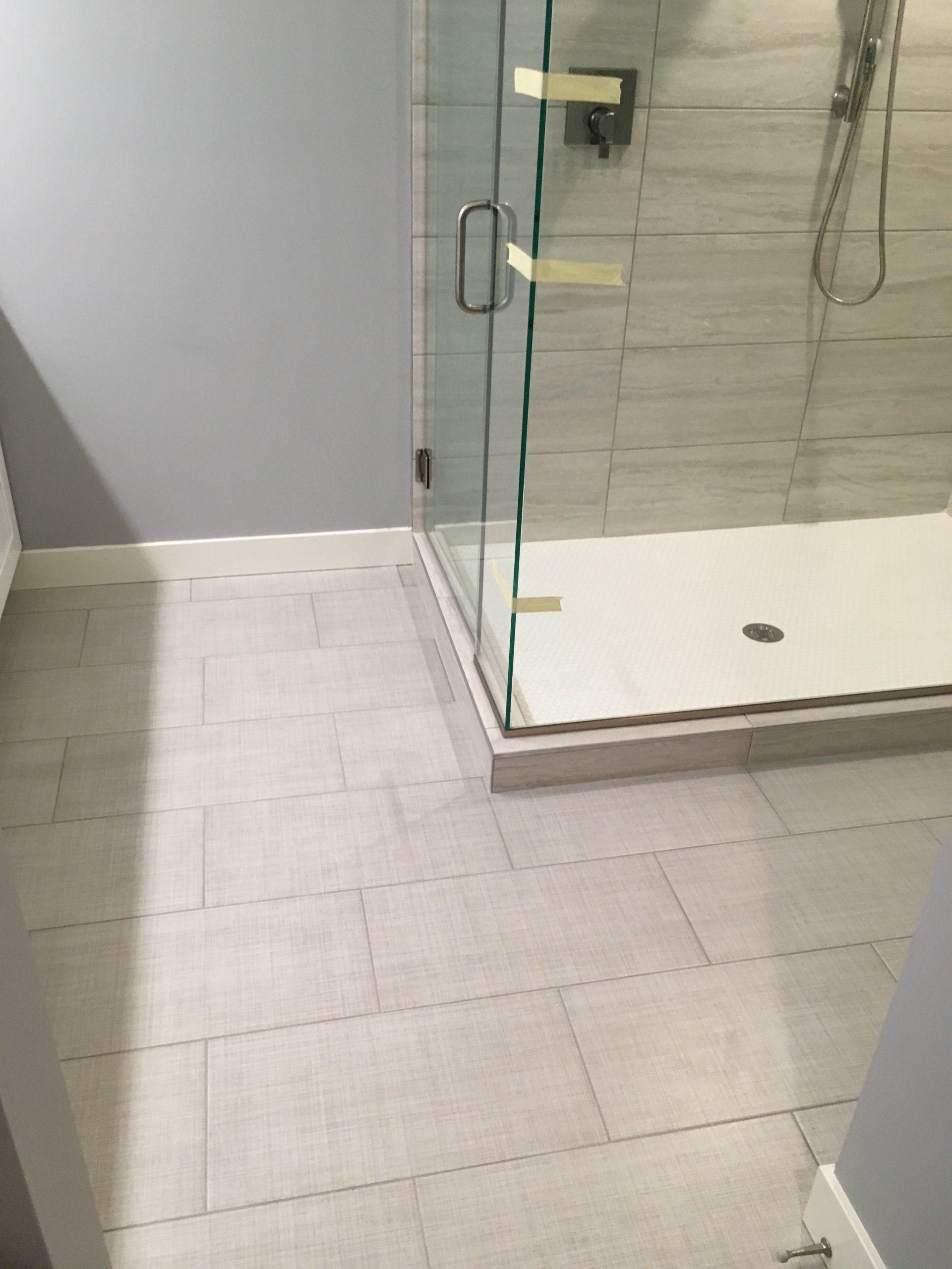 An upgraded bathroom with a walk in shower and a tiled floor.