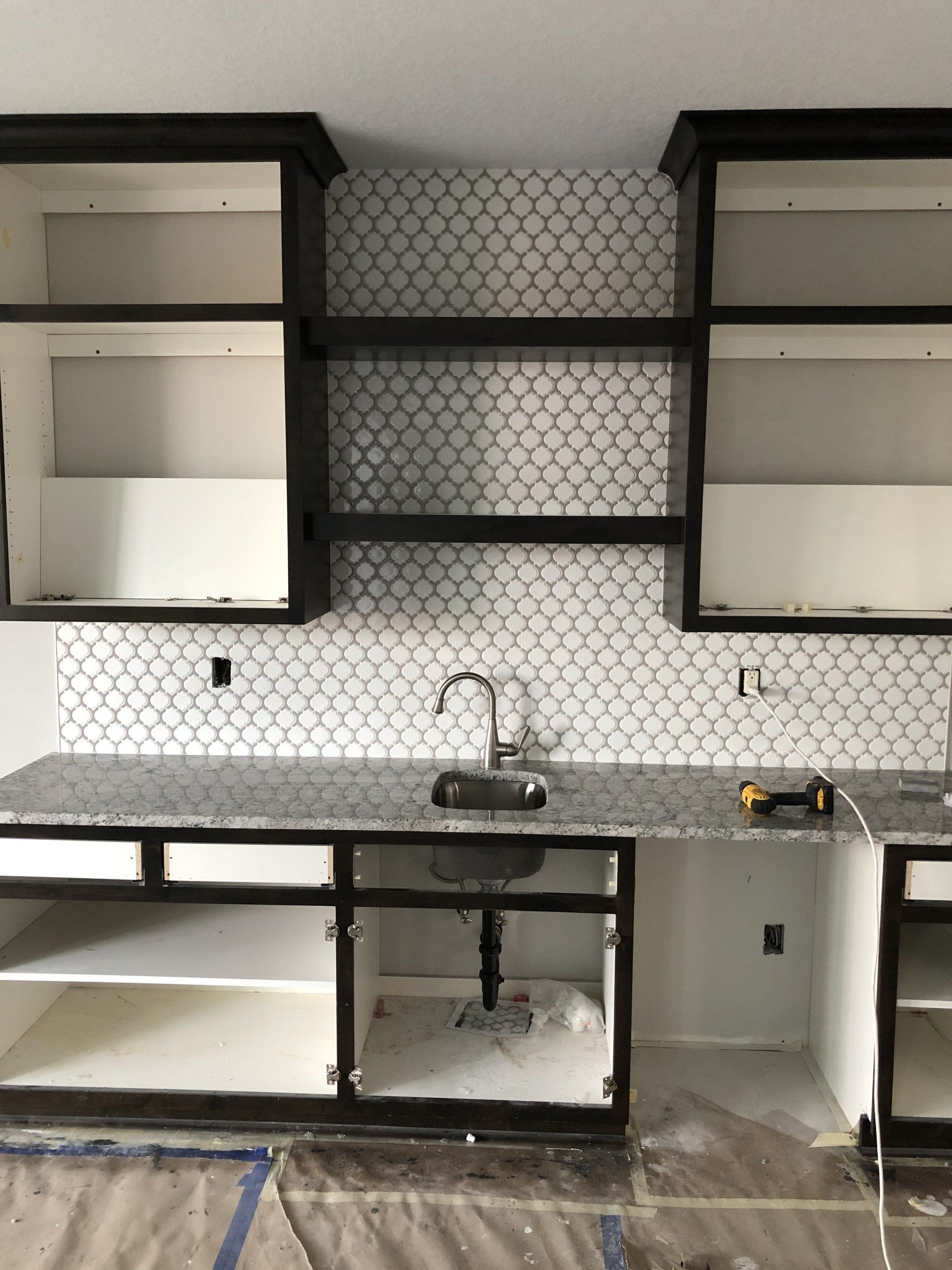 A kitchen reno with a sink , cabinets , and shelves.