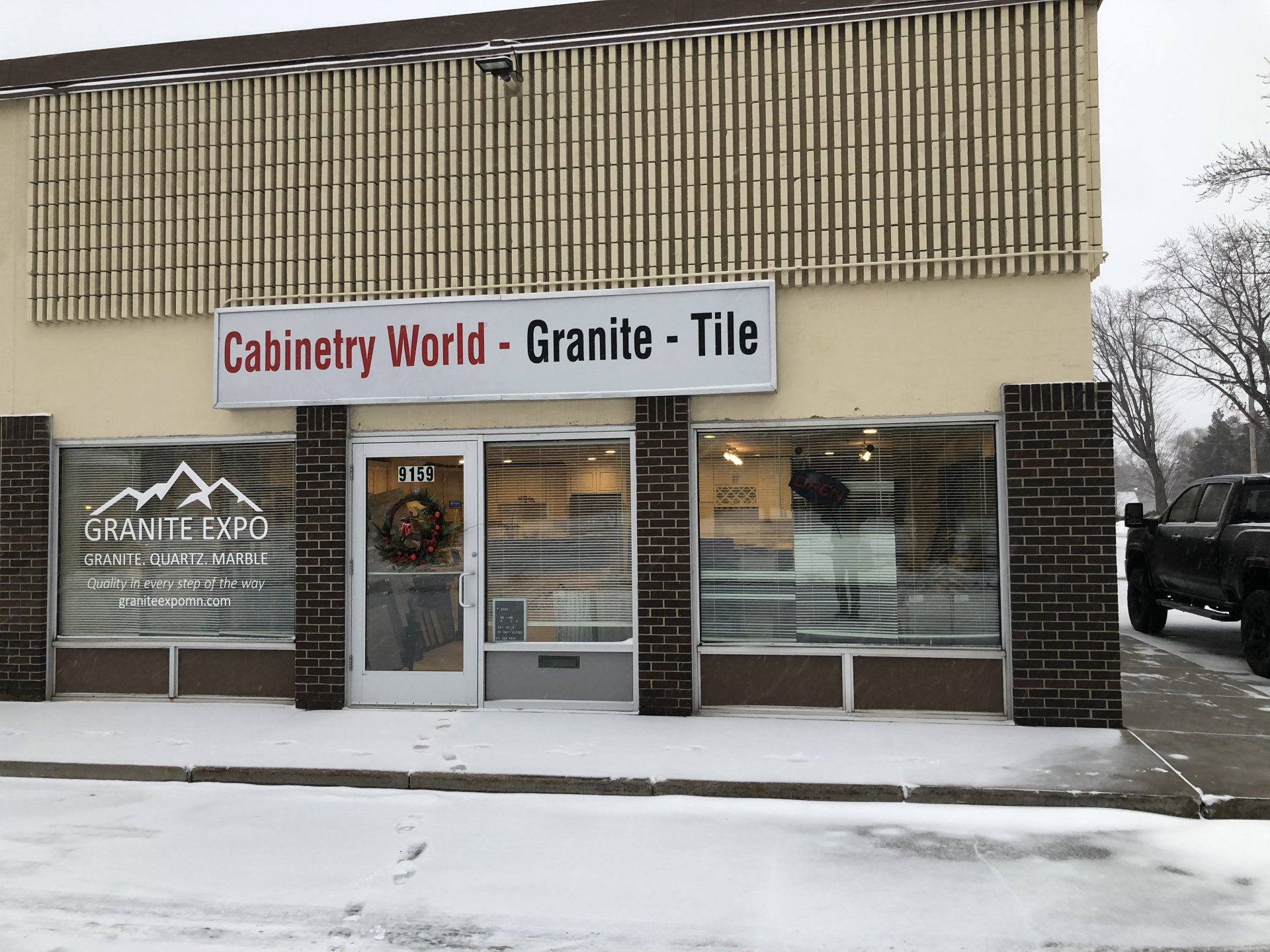 A building with a sign that says cabinetry world granite tile