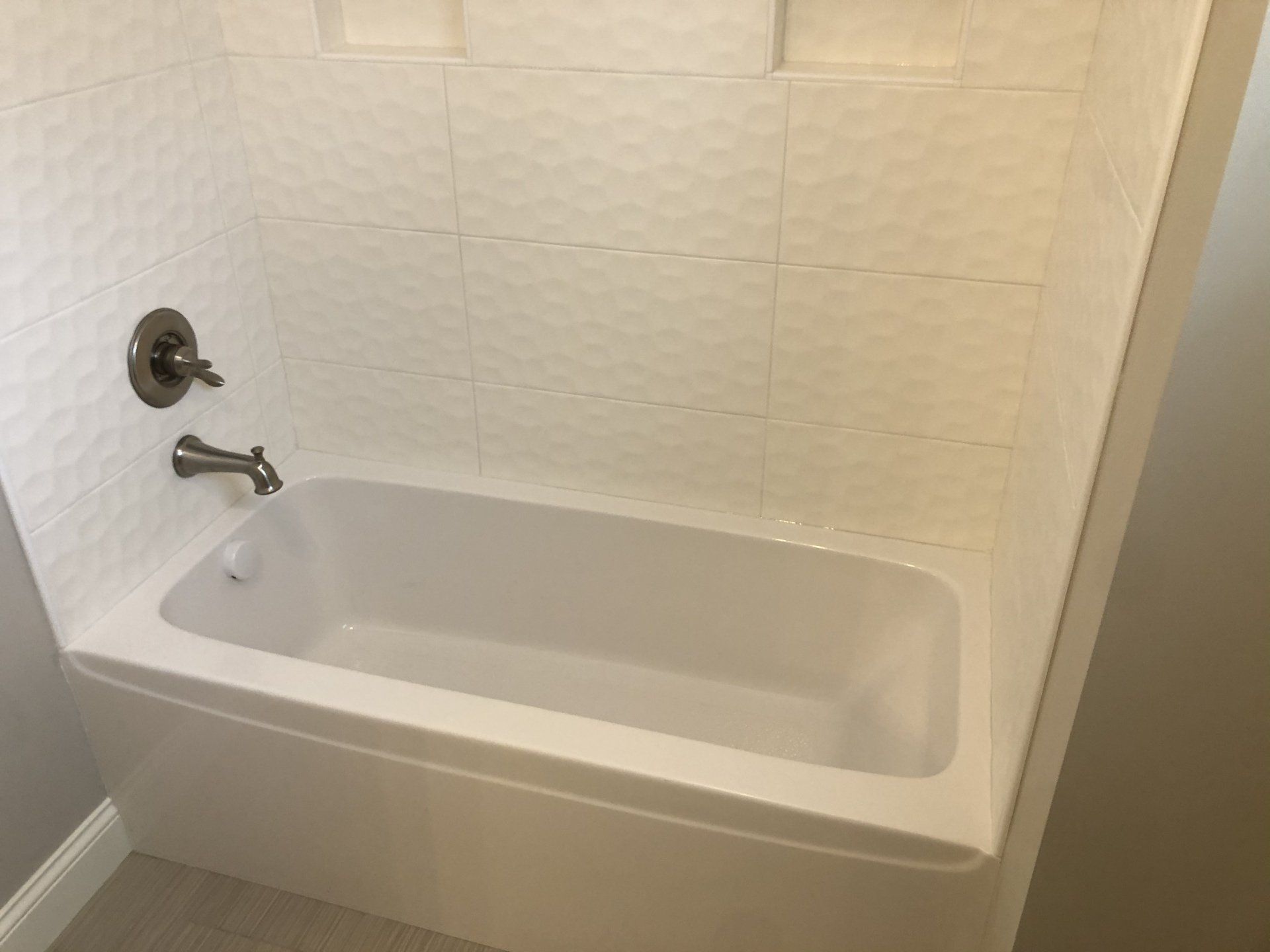 Bathroom shower conversions | A white bathtub is sitting in a bathroom next to a shower.