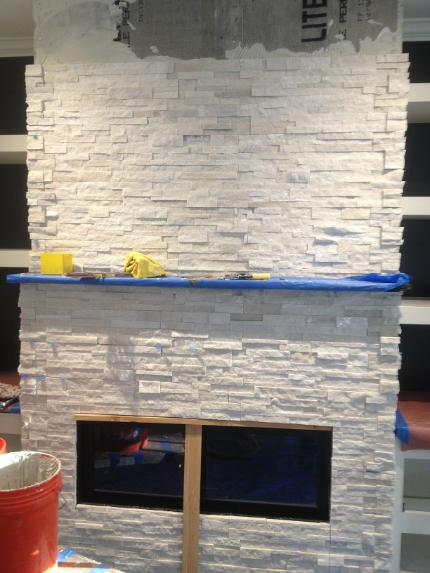 A white brick fireplace with the word lite on the wall