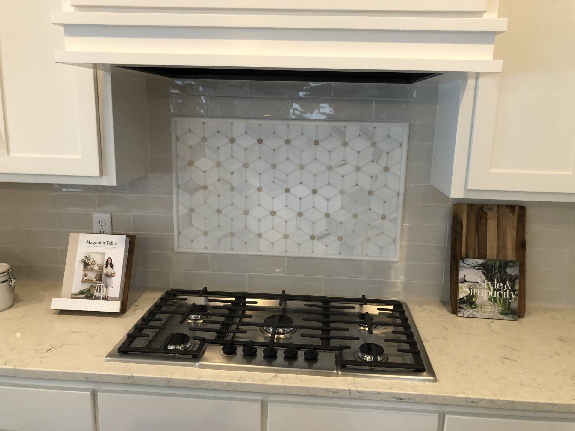 Backsplash installation | A stove top oven is sitting on top of a counter in a kitchen.