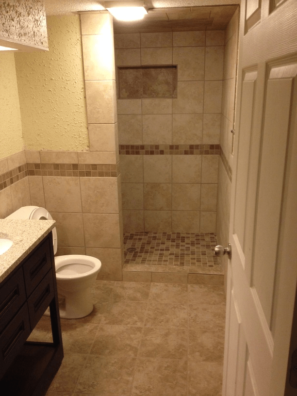A bathroom for seniors with a toilet , sink , and walk in shower.