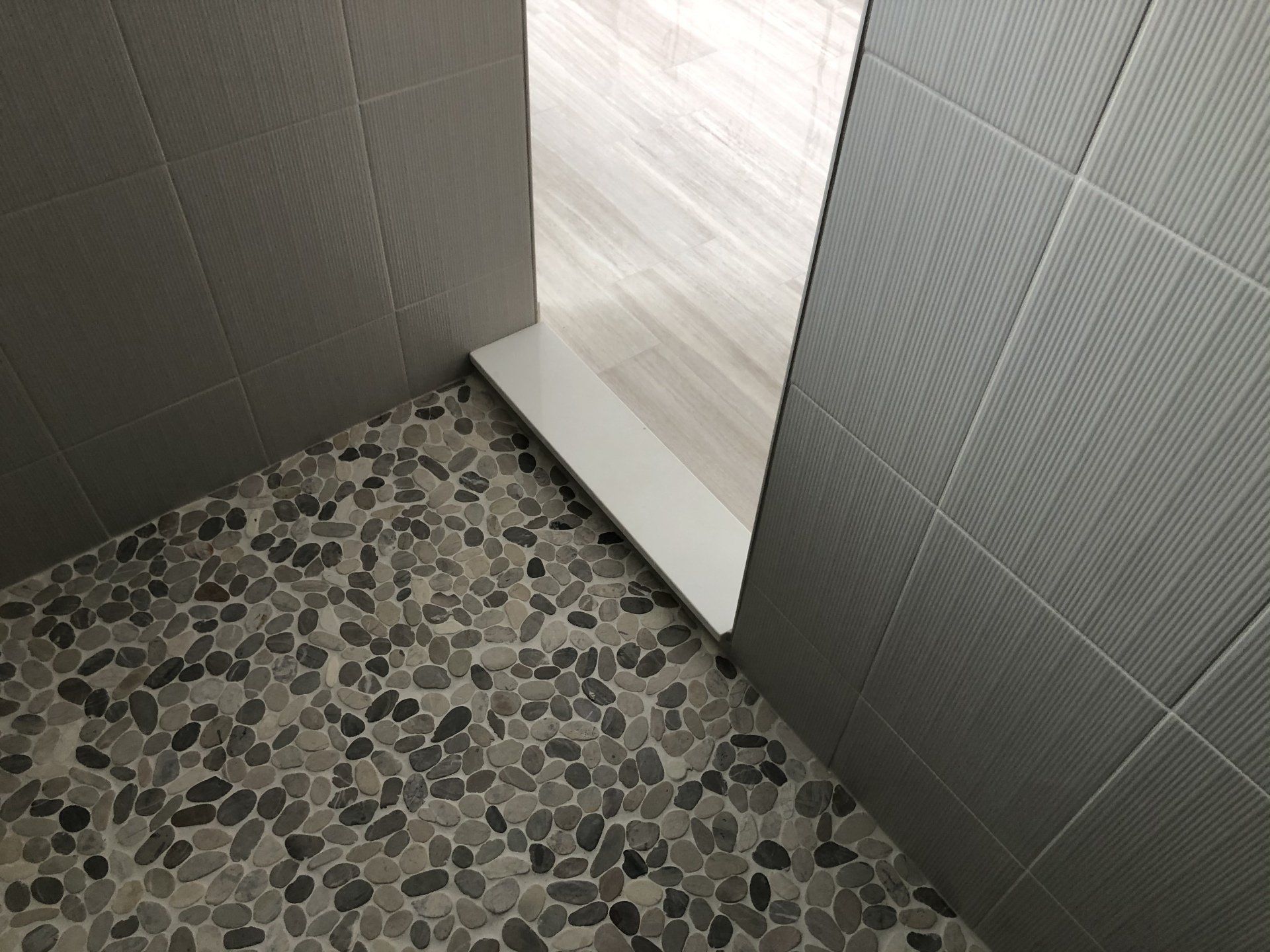 Bathroom redo with a tiled floor and a door that is open.