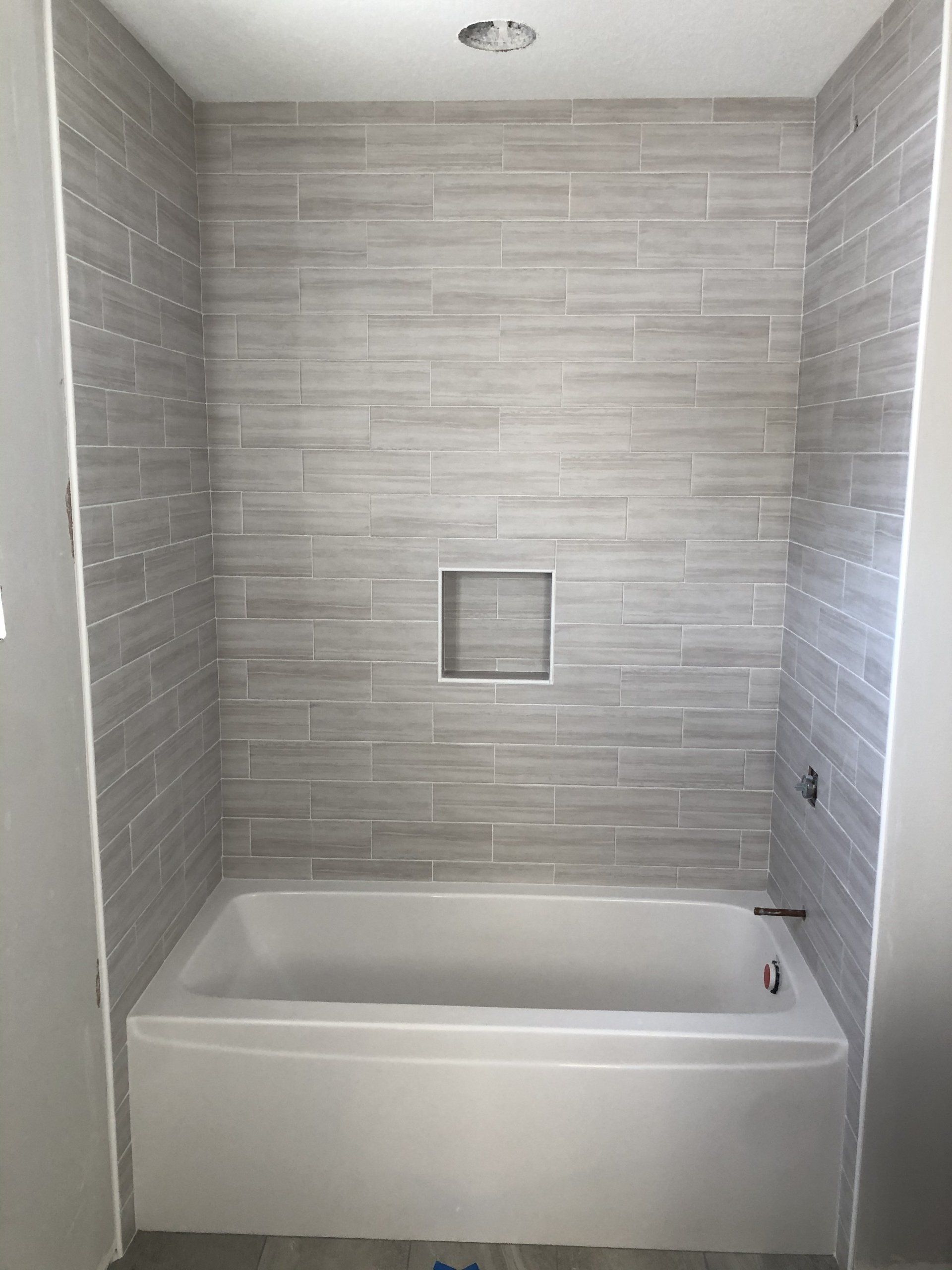 Bathroom shower conversions | A bathtub is sitting in a bathroom next to a shower.