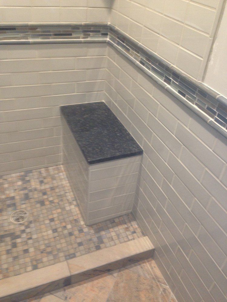There is a bench for seniors in the corner of the shower.