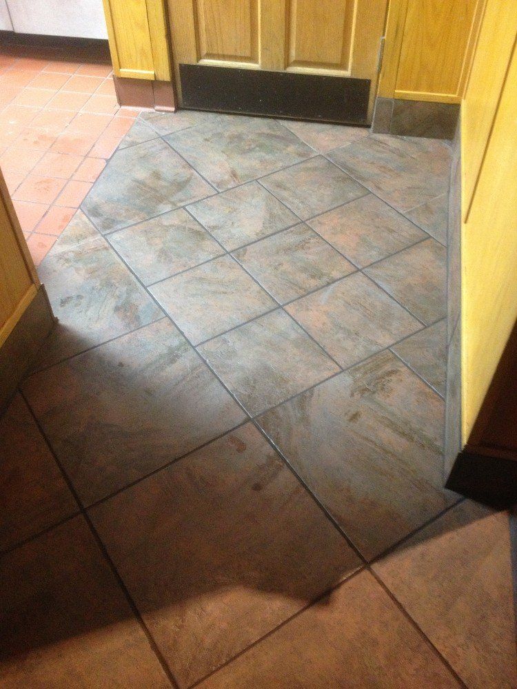 Commercial tiling contractors work | BYN the Tile Crew | A tiled floor in a kitchen with a door in the background.