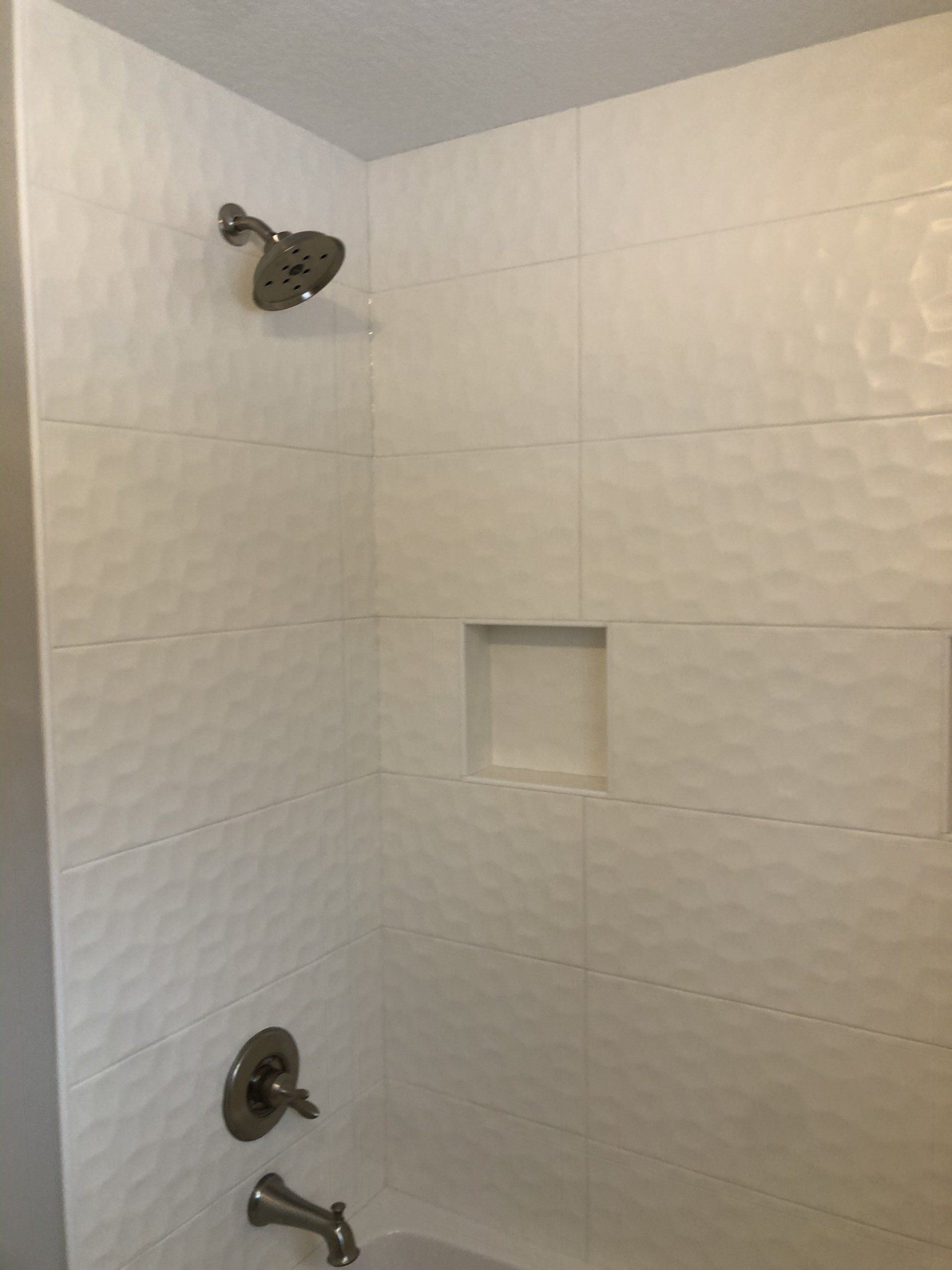 A shower with a tub and a shower head in a bathroom.