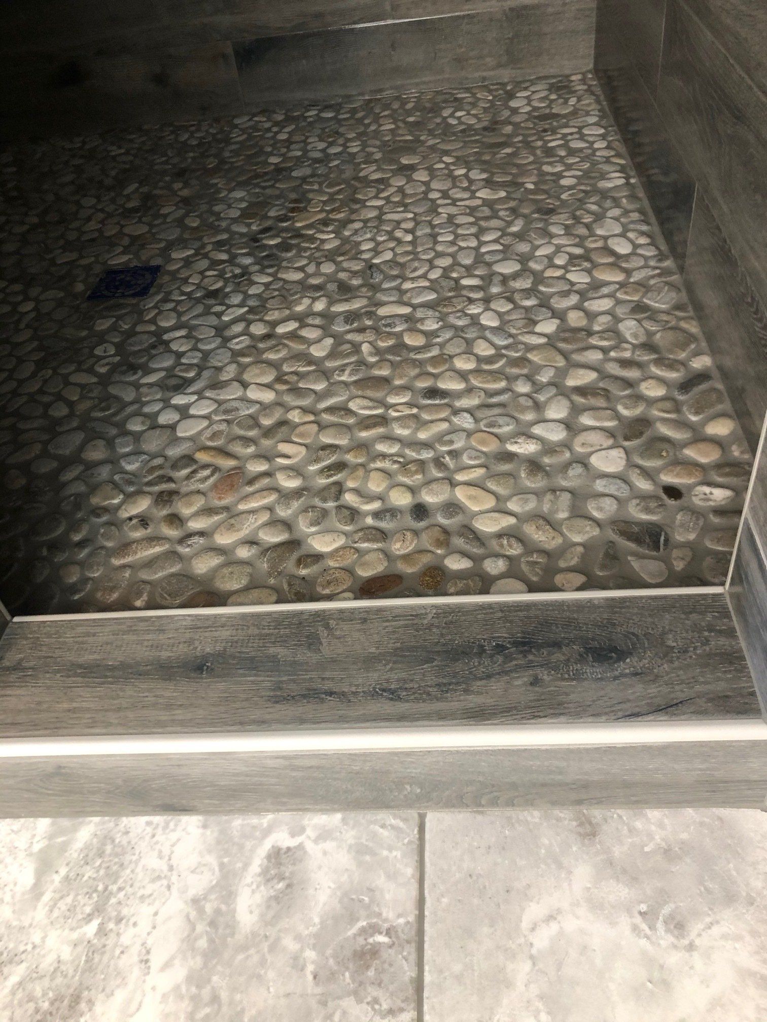 A walk in shower idea with a stone floor and steps.