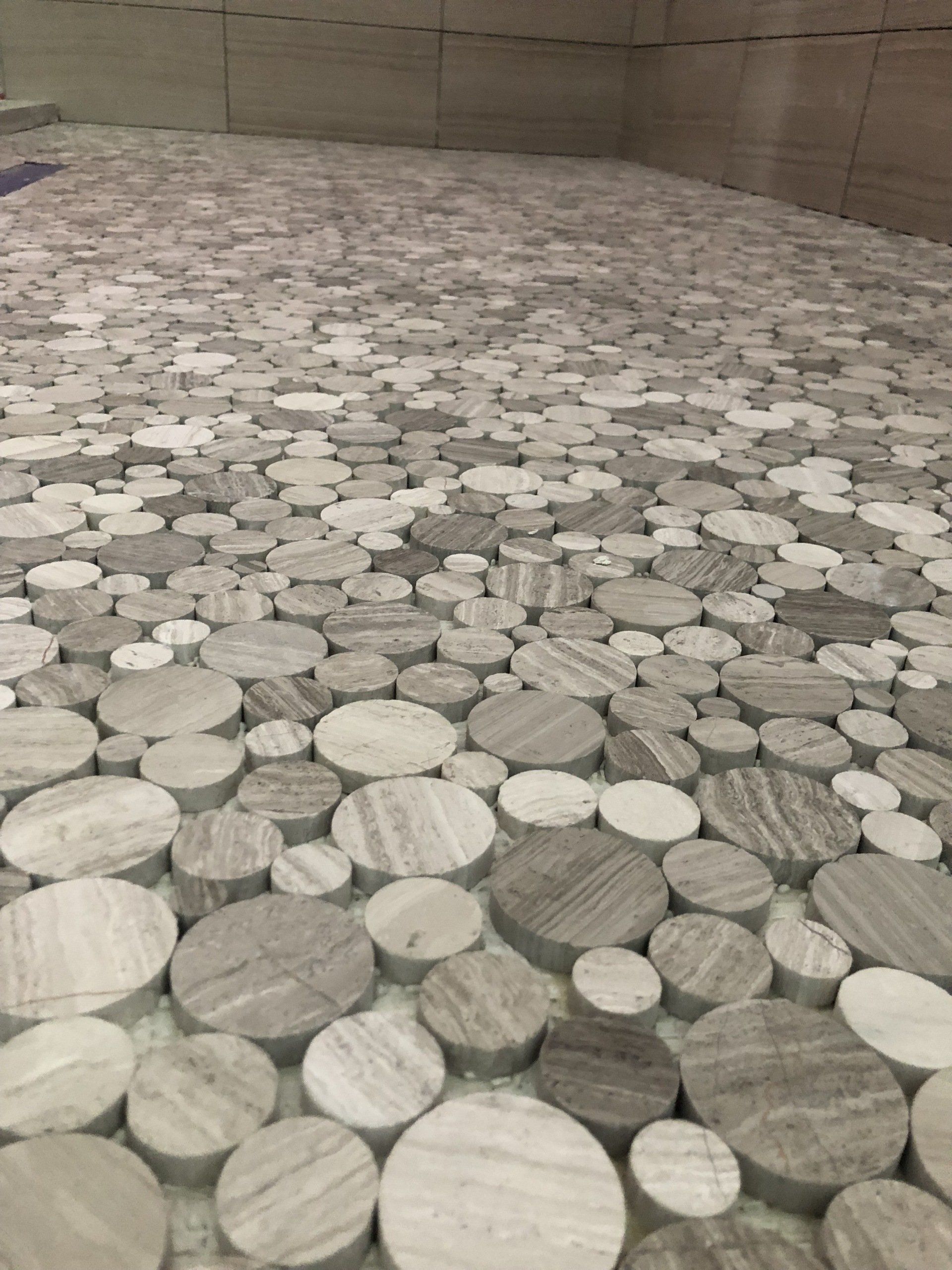 Custom shower tile designs | A bathroom floor with a pattern of circles on it