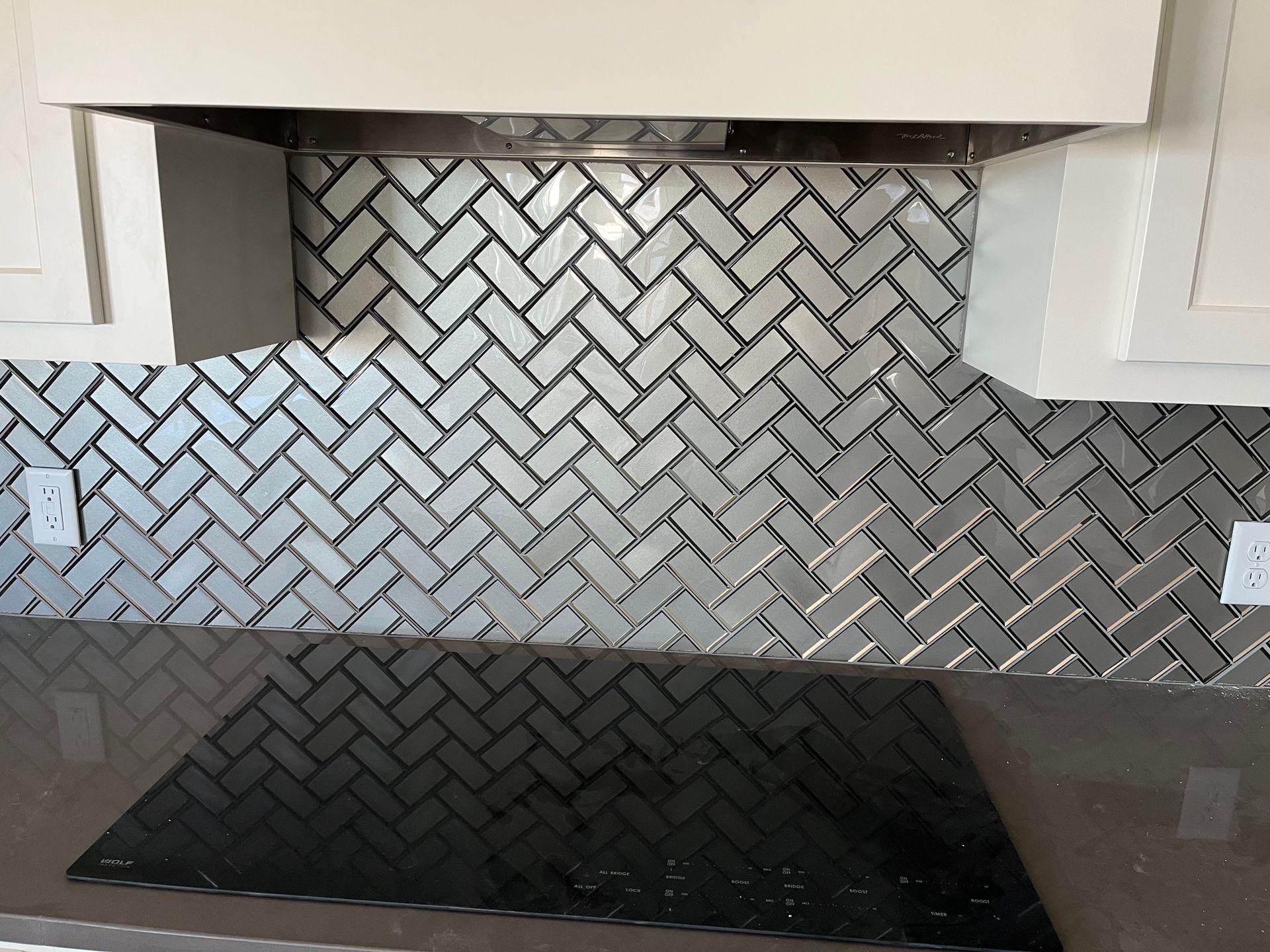 A kitchen remodel with white cabinets and a backsplash