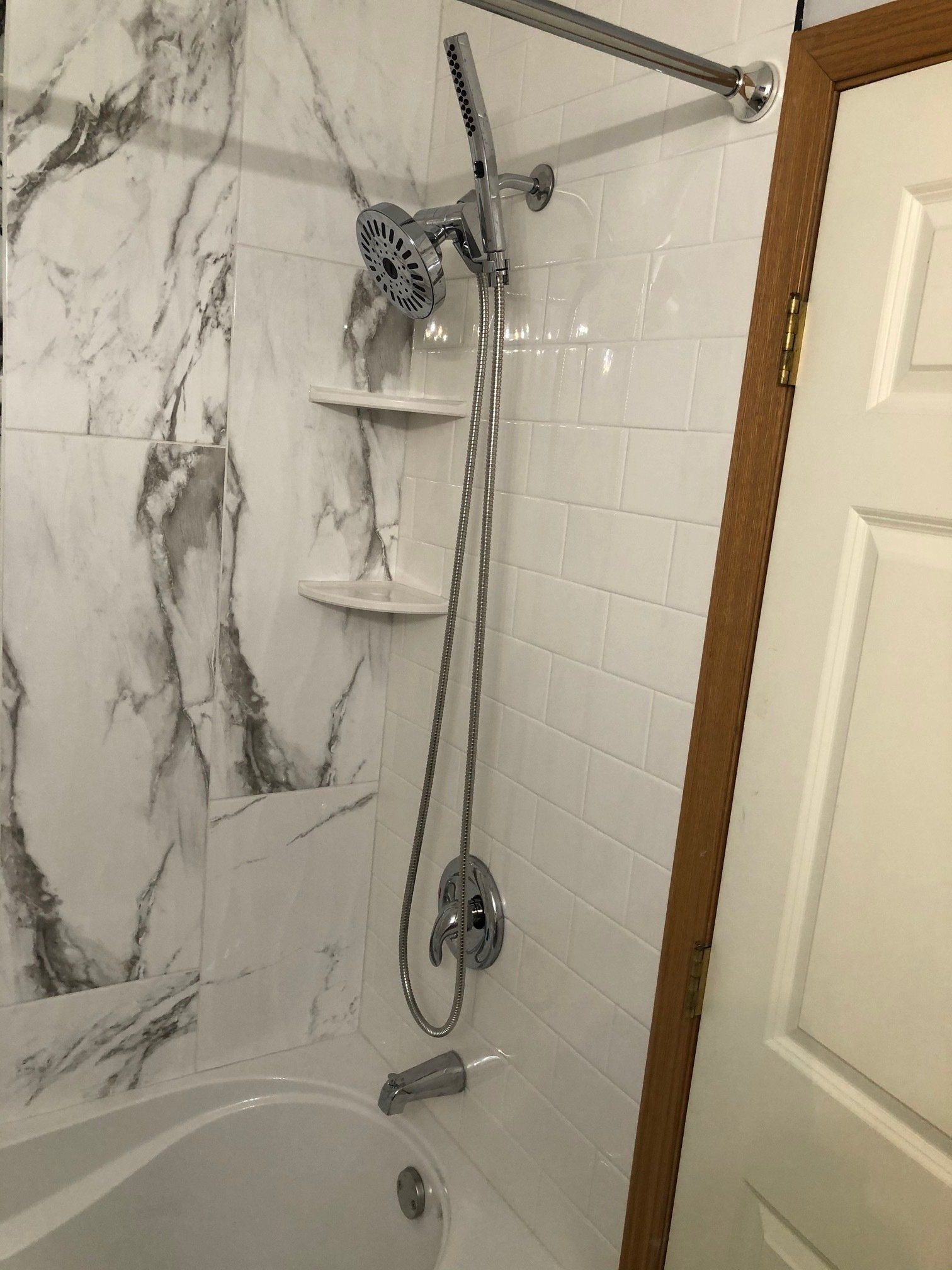 Small bathroom renovations | A bathroom with a bathtub , shower , and marble wall.