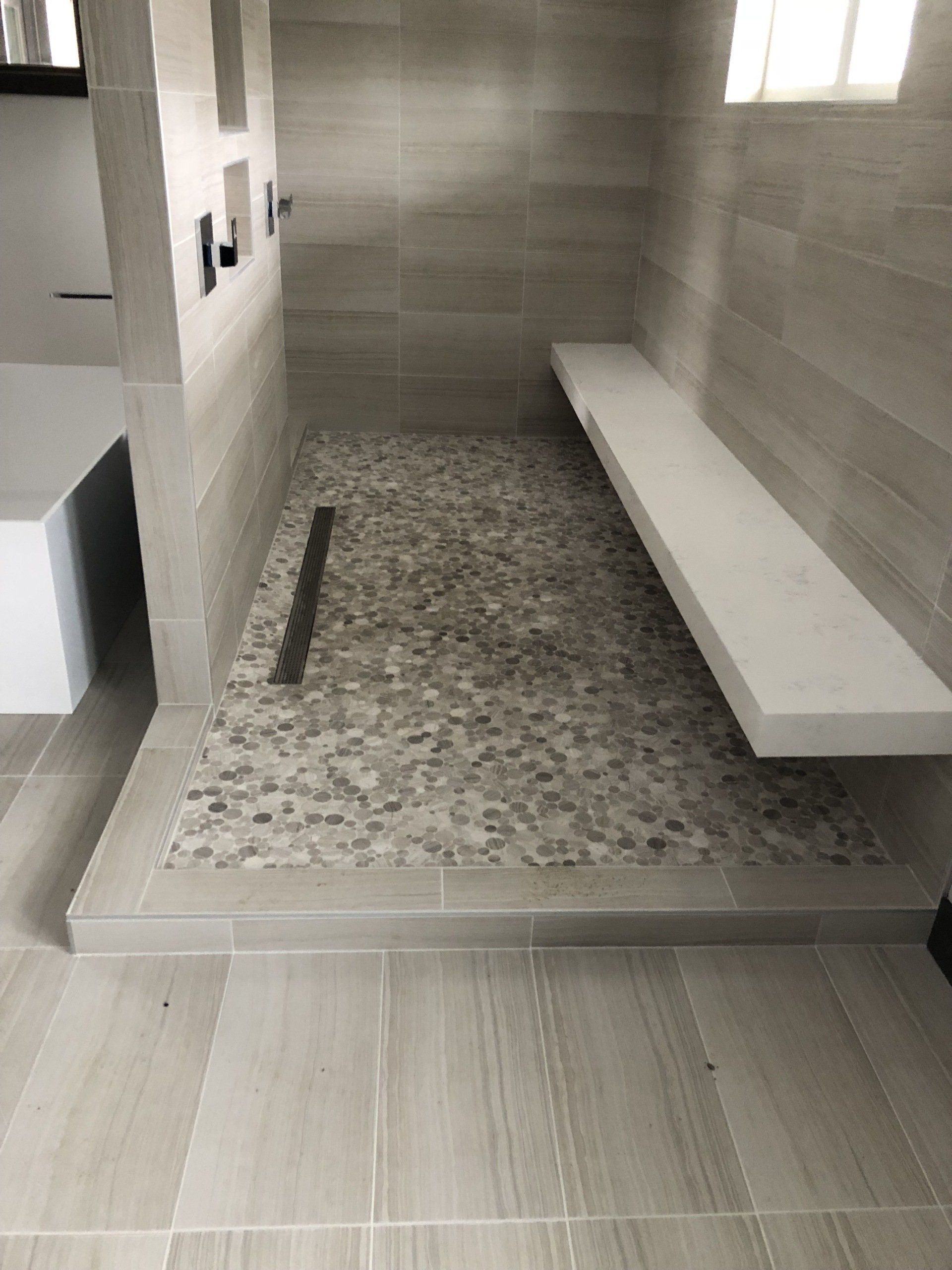 Walk-in accessible bathroom | A bathroom with a bench and a walk in shower.