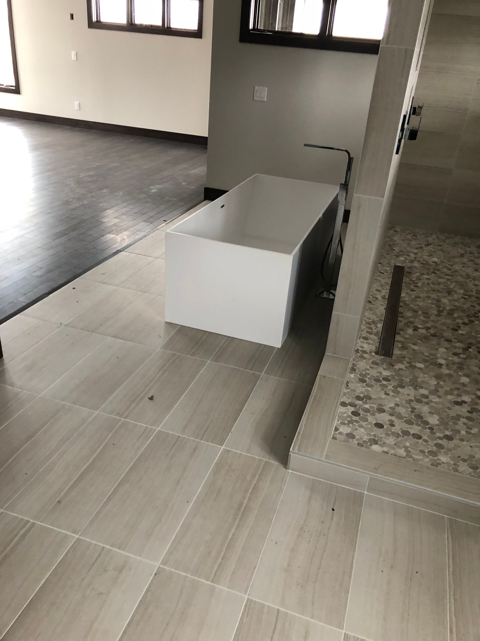 A bathtub is sitting on a tiled floor in a bathroom.