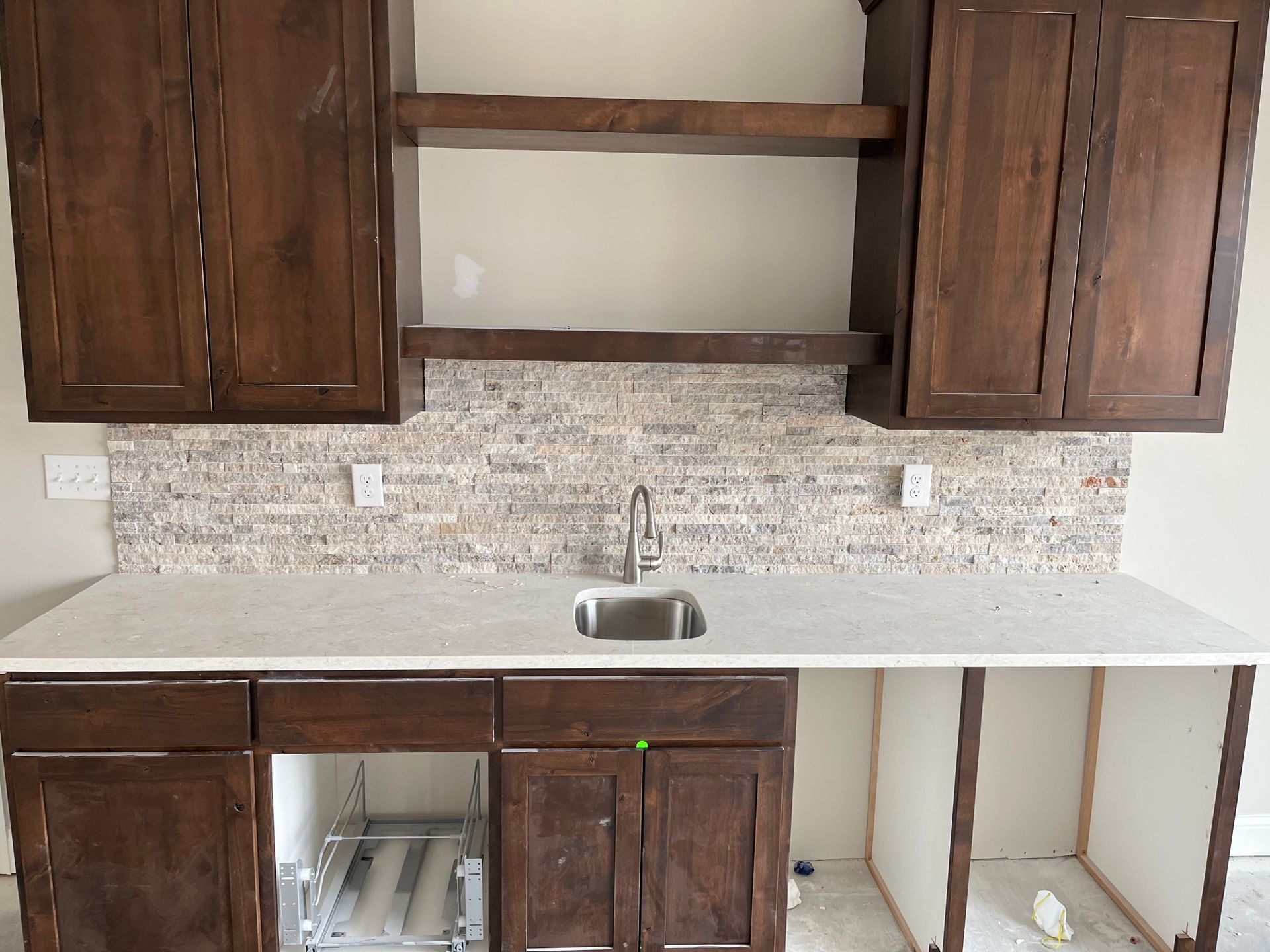 A kitchen backsplash with wooden cabinets and a sink