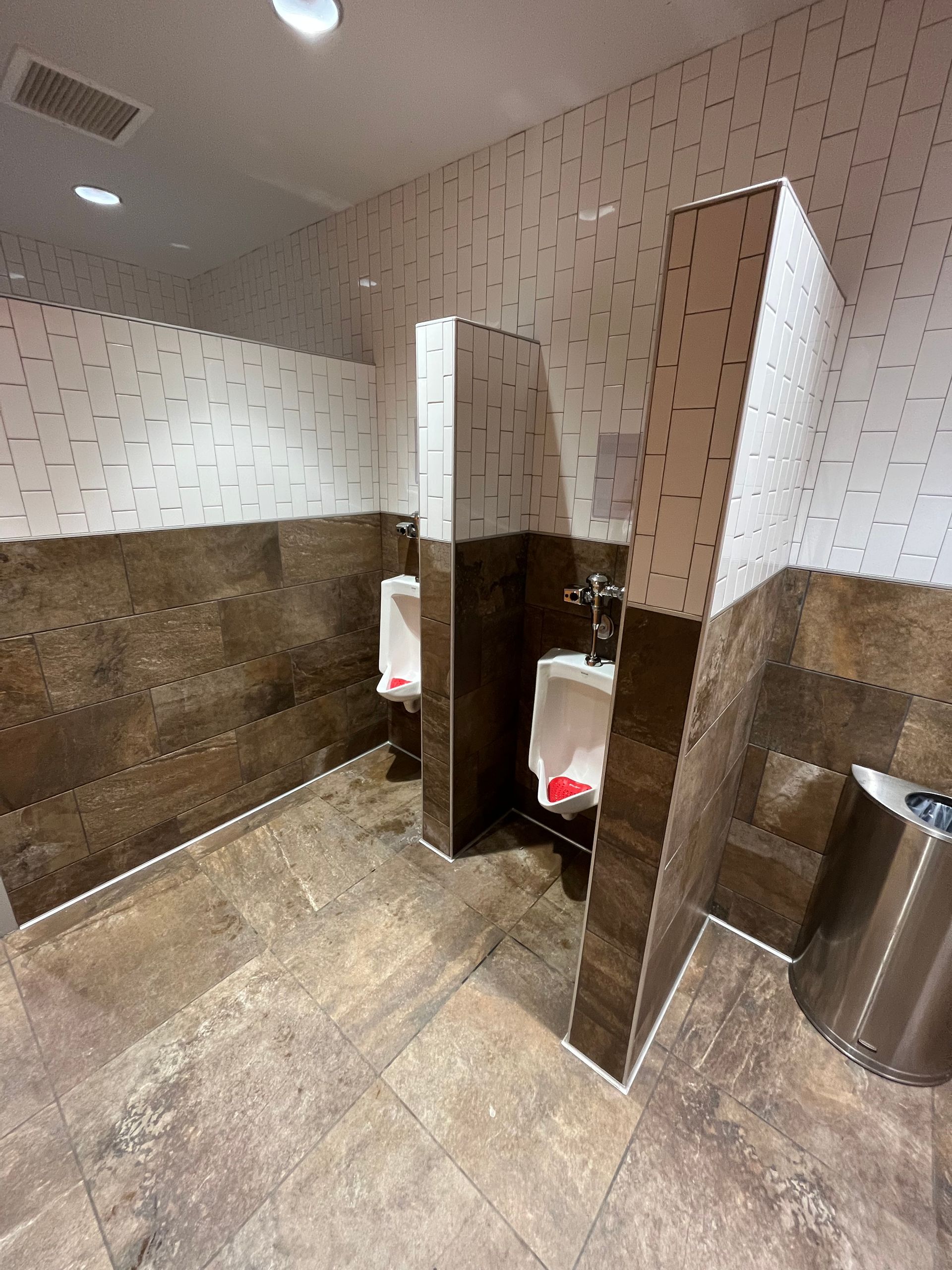 Commercial tiling contractors work | BYN the Tile Crew | A bathroom with two urinals and a trash can
