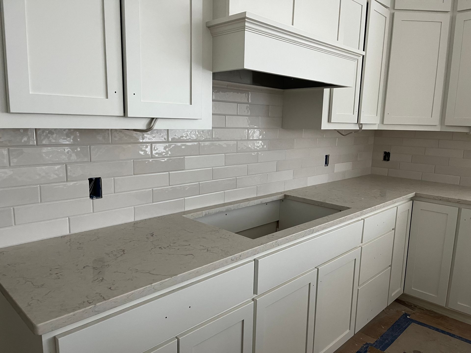 A kitchen backsplash with white cabinets and a sink.