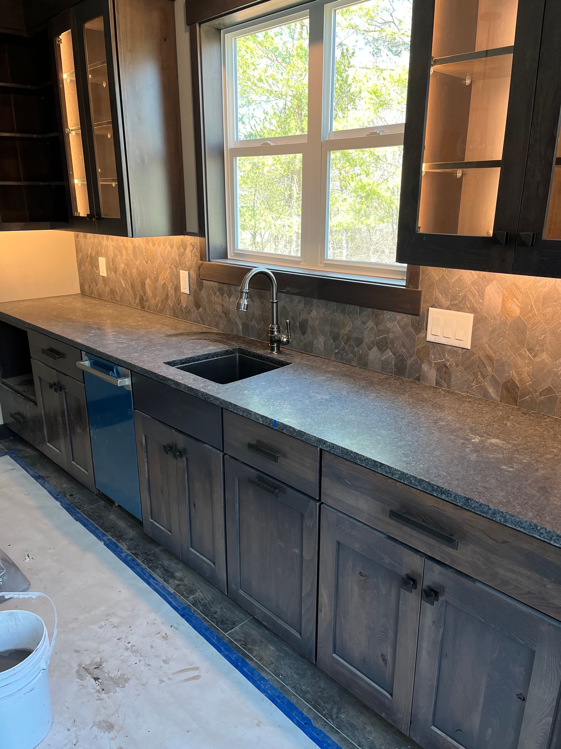 A  renovated kitchen with a sink , cabinets and a window