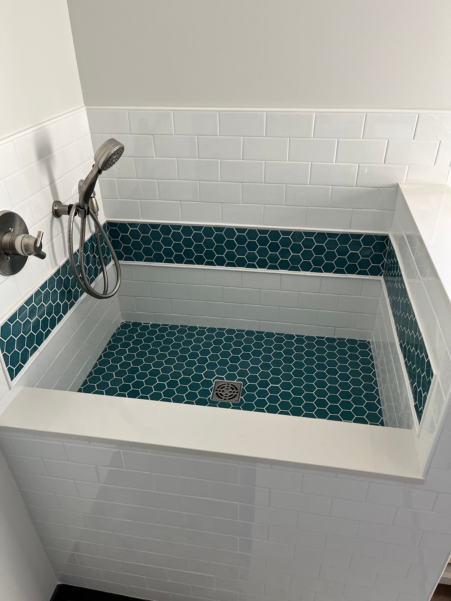 Shower to bathtub conversion | A bathtub with a shower head on top of it in a bathroom.