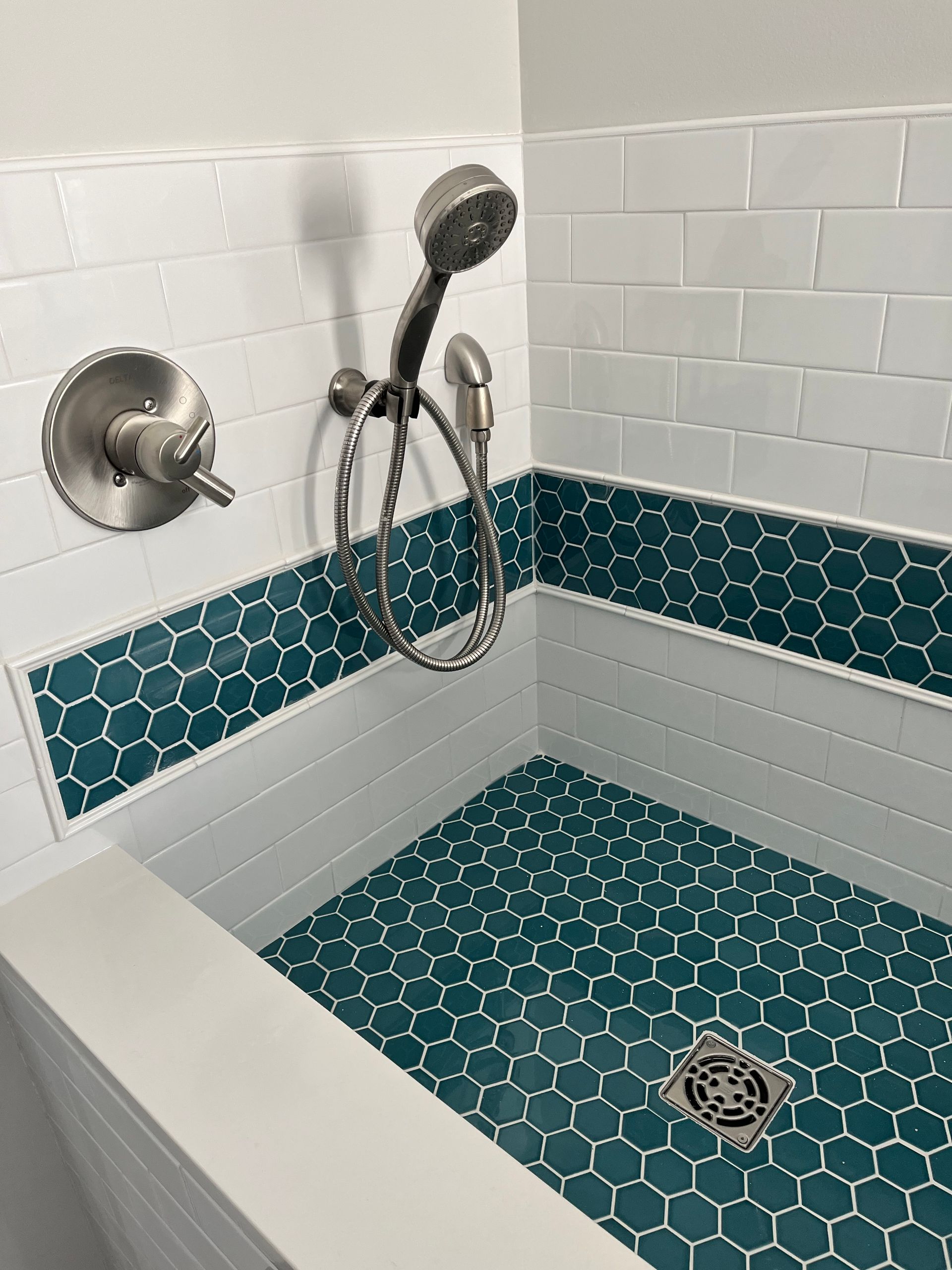 Shower to bathtub conversion | A shower with a shower head and a drain in a bathroom.