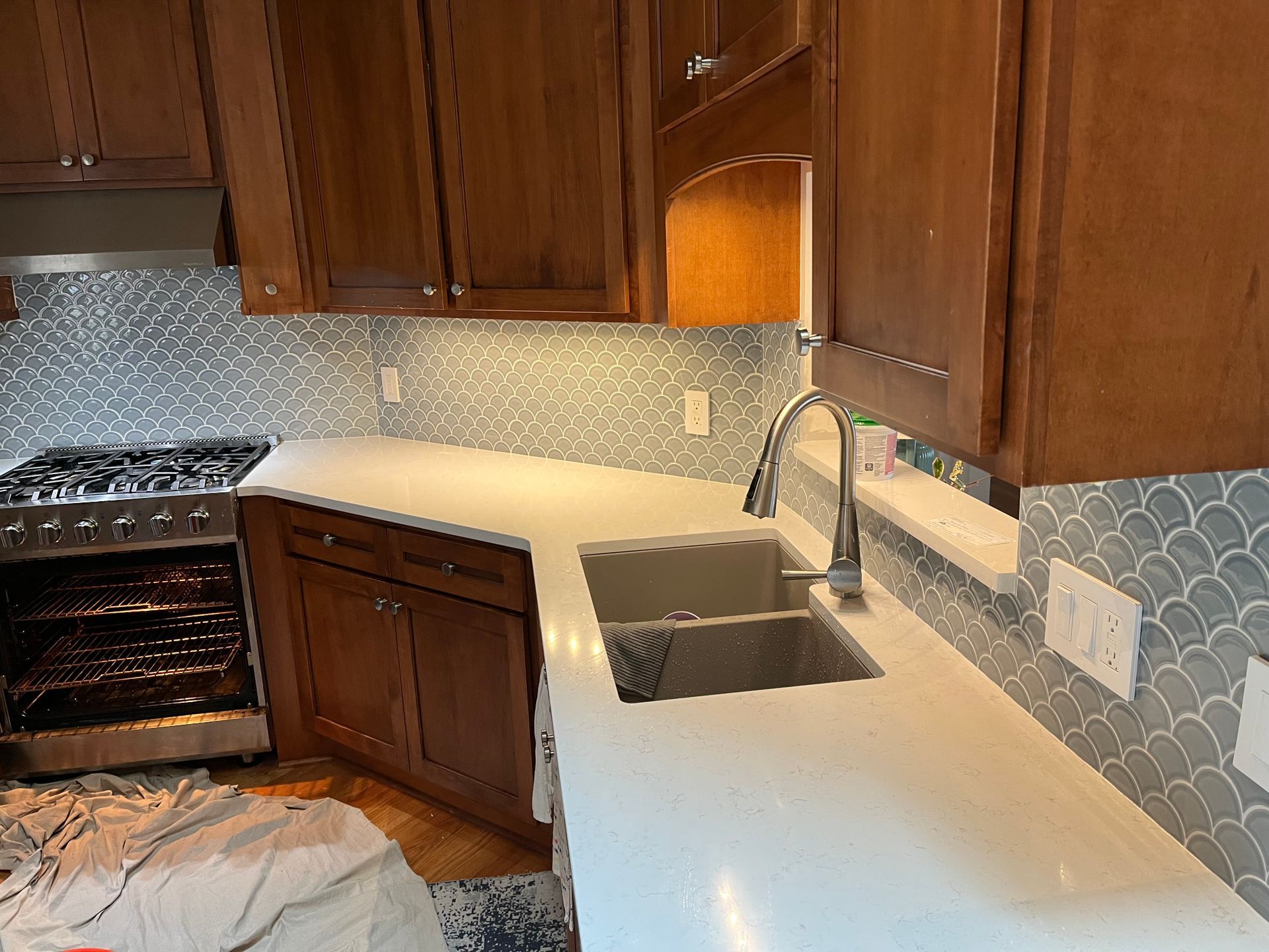 A kitchen with a sink , stove , and cabinets.