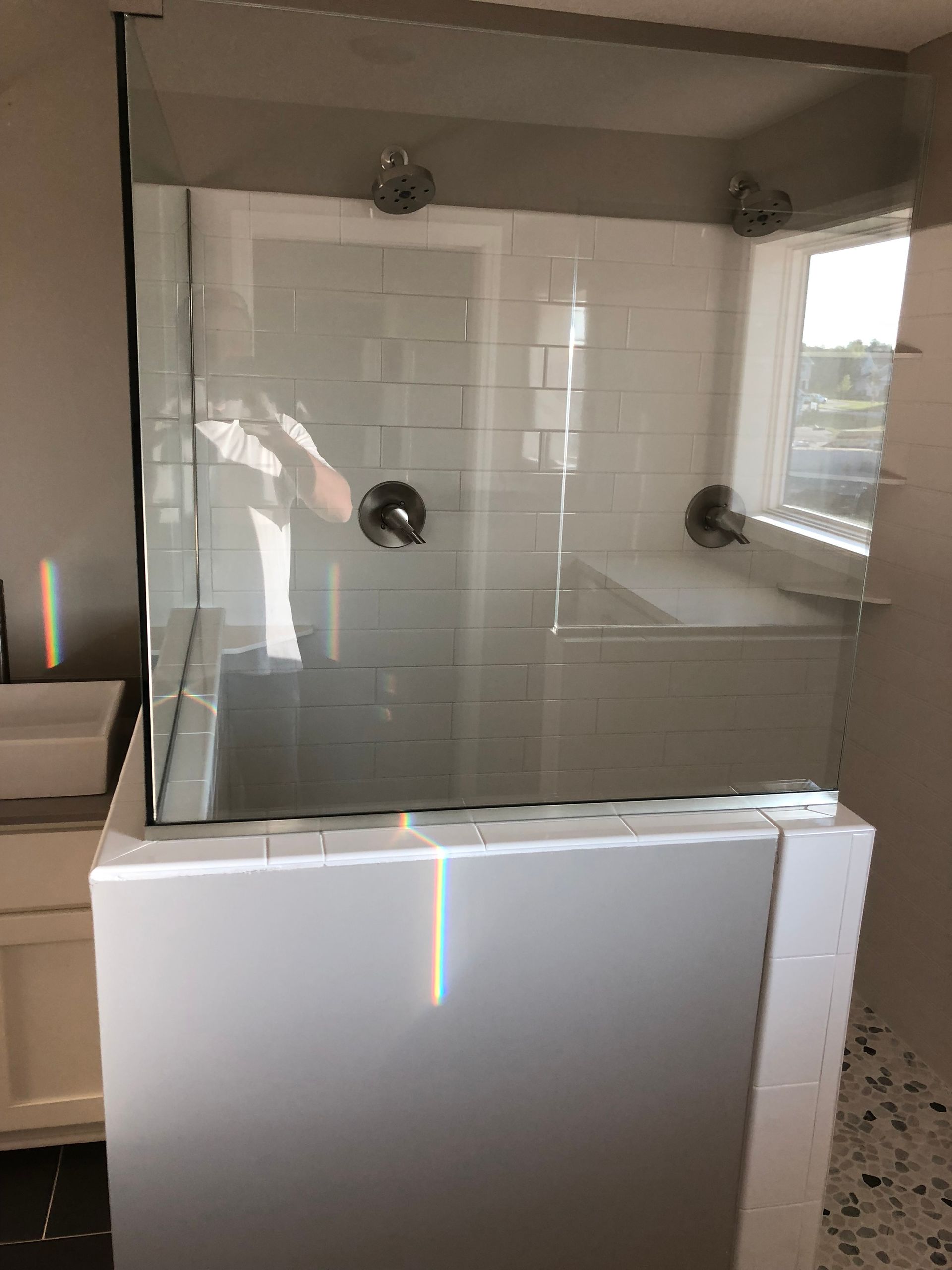A bathroom with a walk in shower and a sink.
