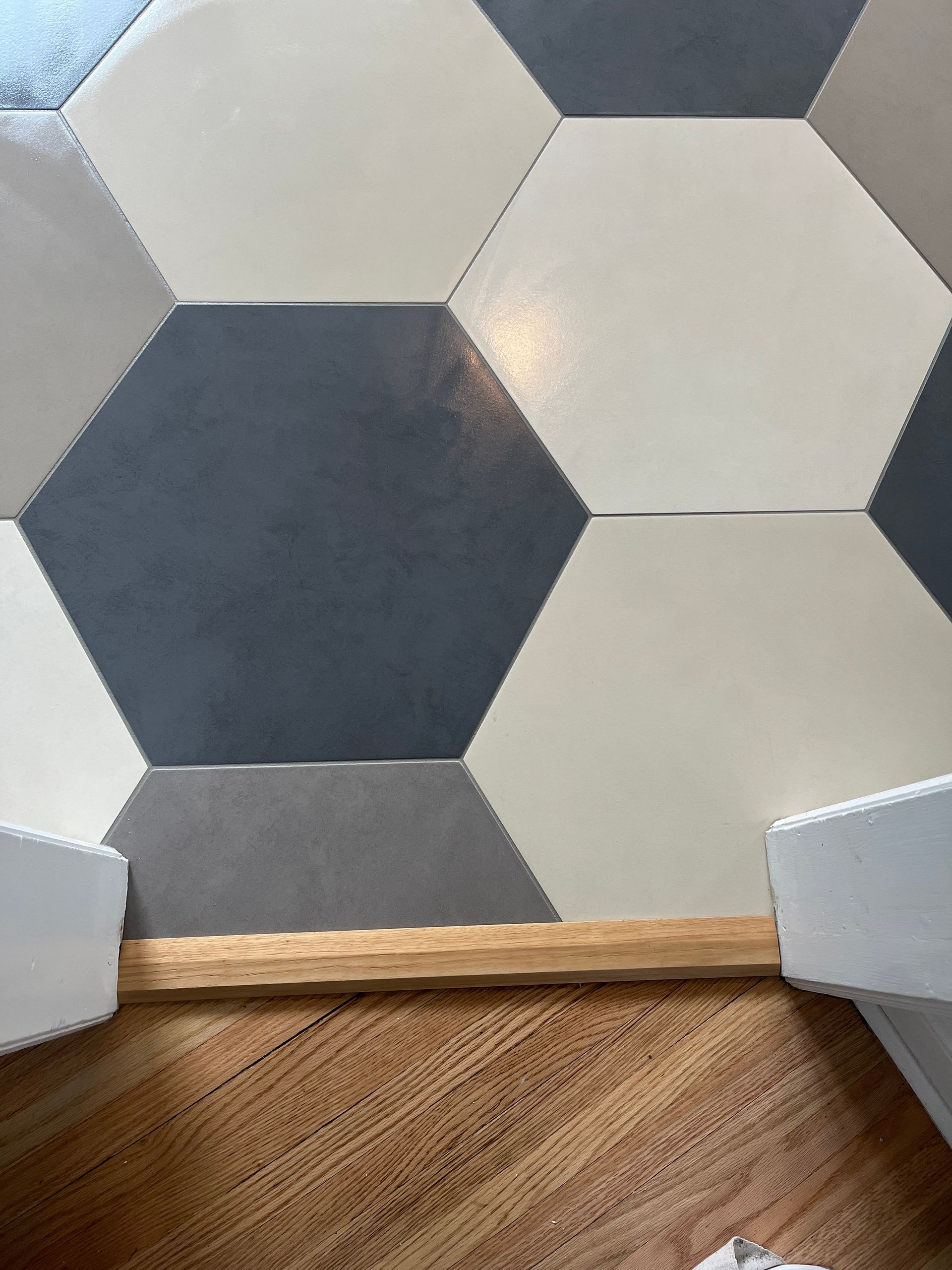A close up of a hexagon tile floor in a bathroom.