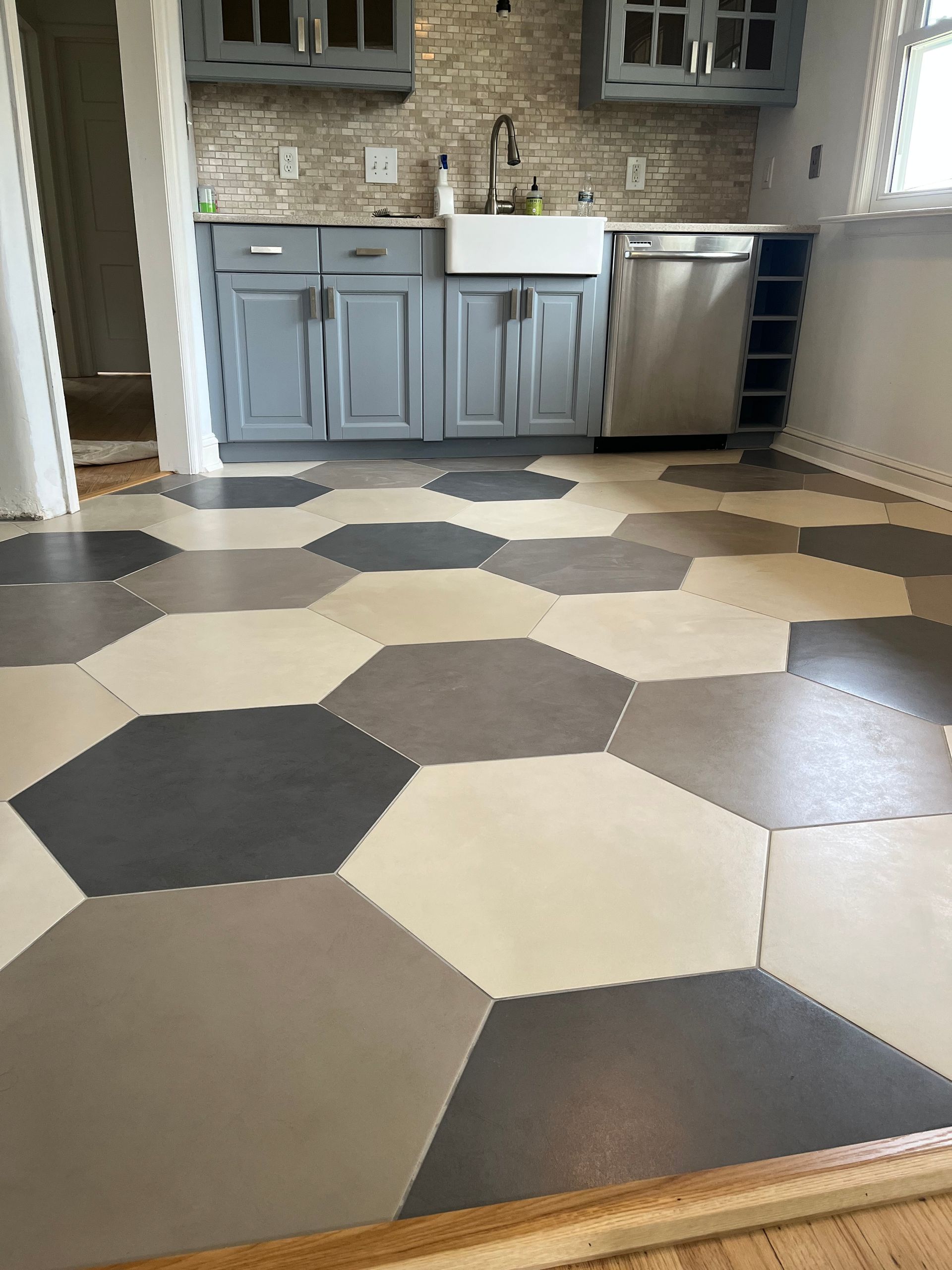 A kitchen with a hexagonal tile floor and a sink.