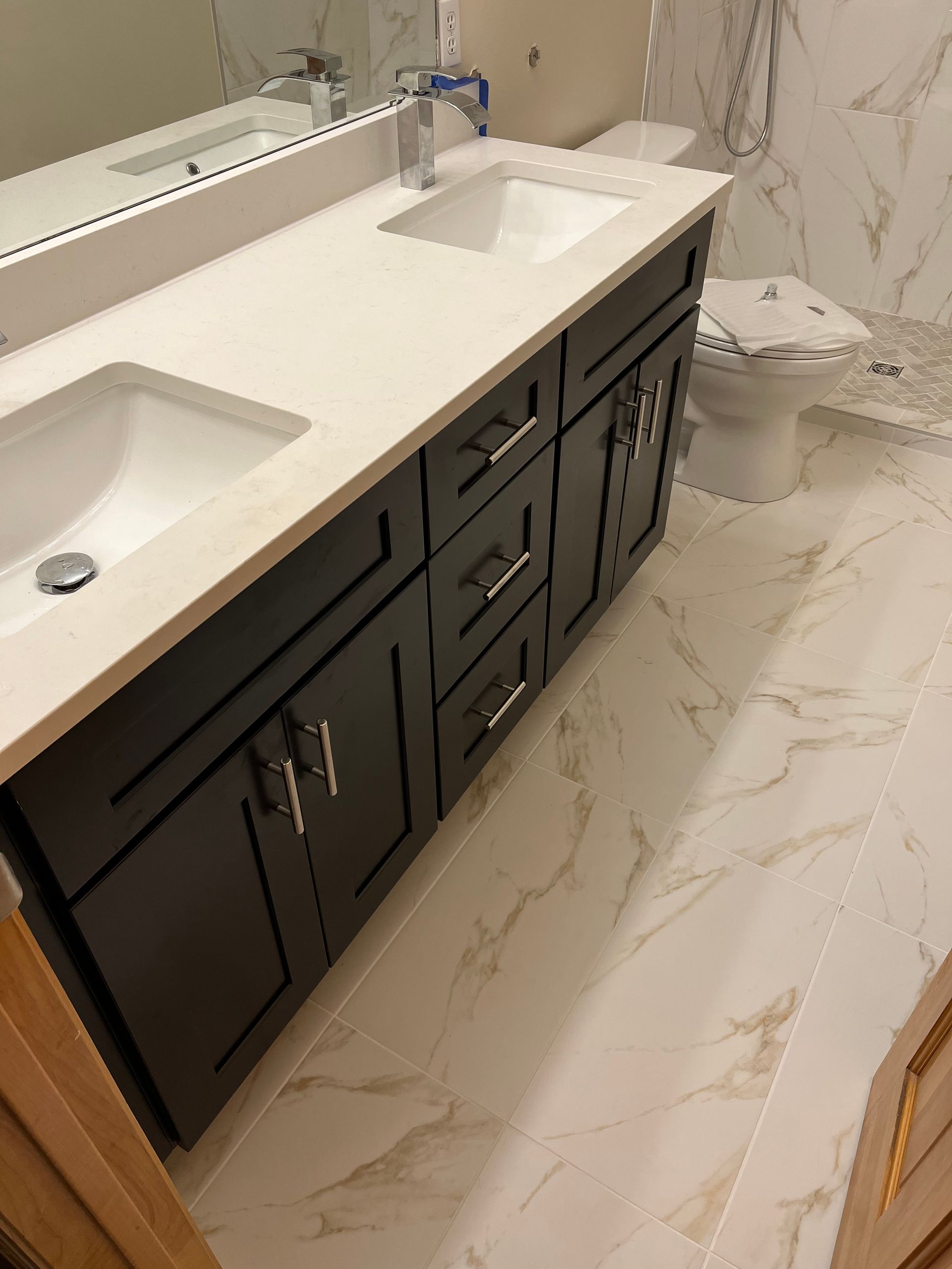 Master bathroom renovation | A bathroom with two sinks , a toilet and a mirror.