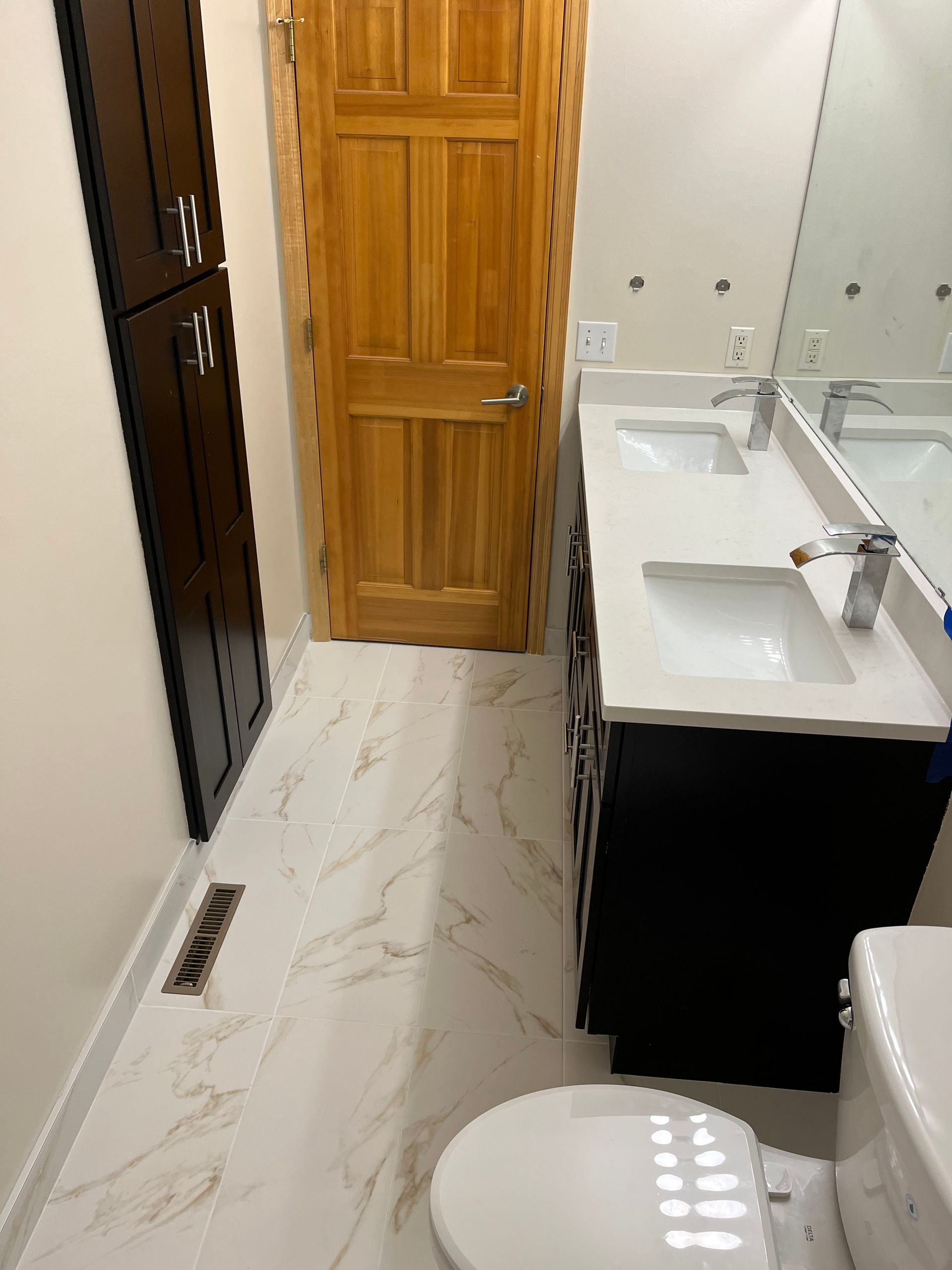 Small bathroom renovations | A bathroom with two sinks , a toilet and a mirror.