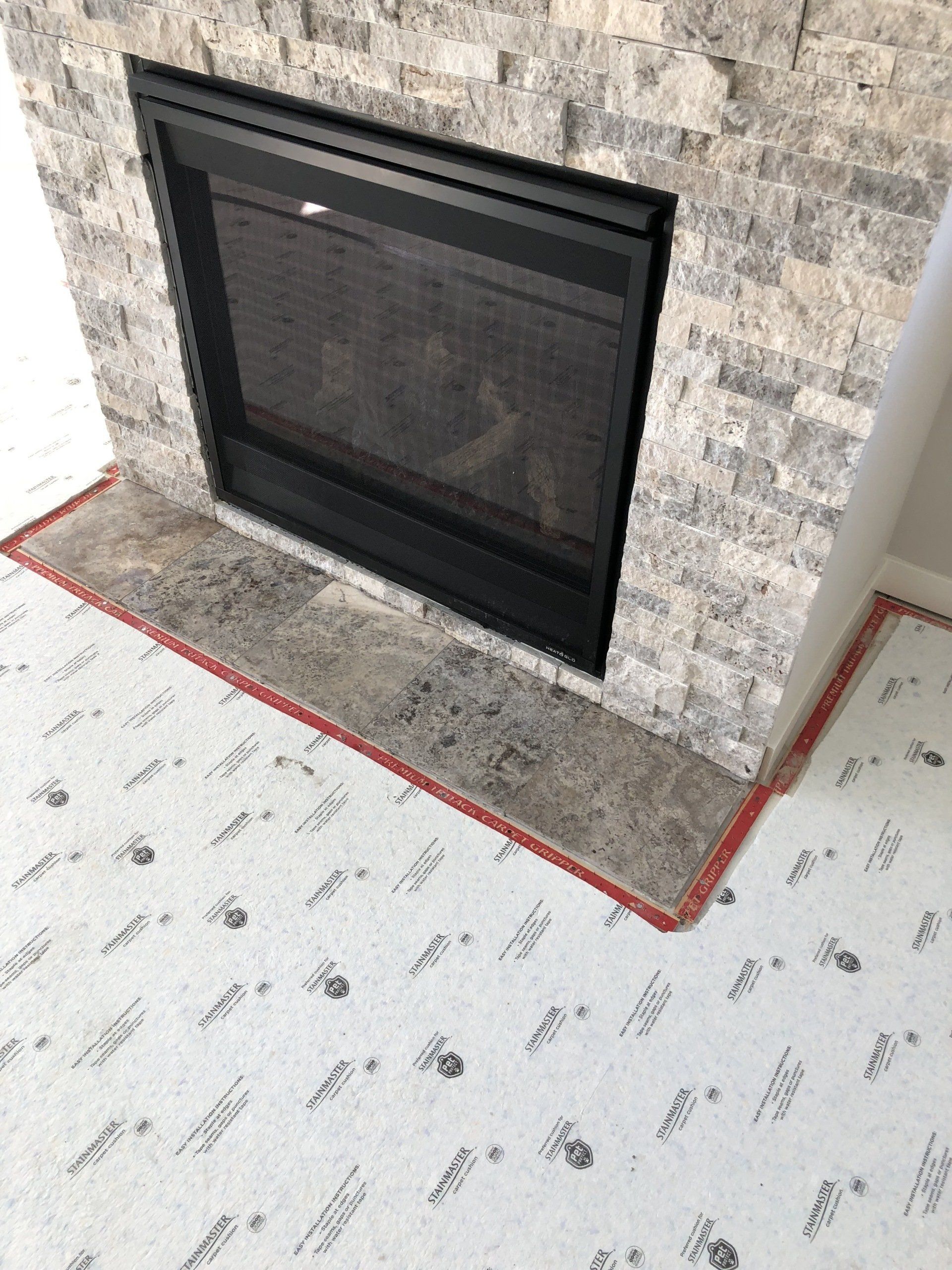 A fireplace in a living room with a carpet underneath it.