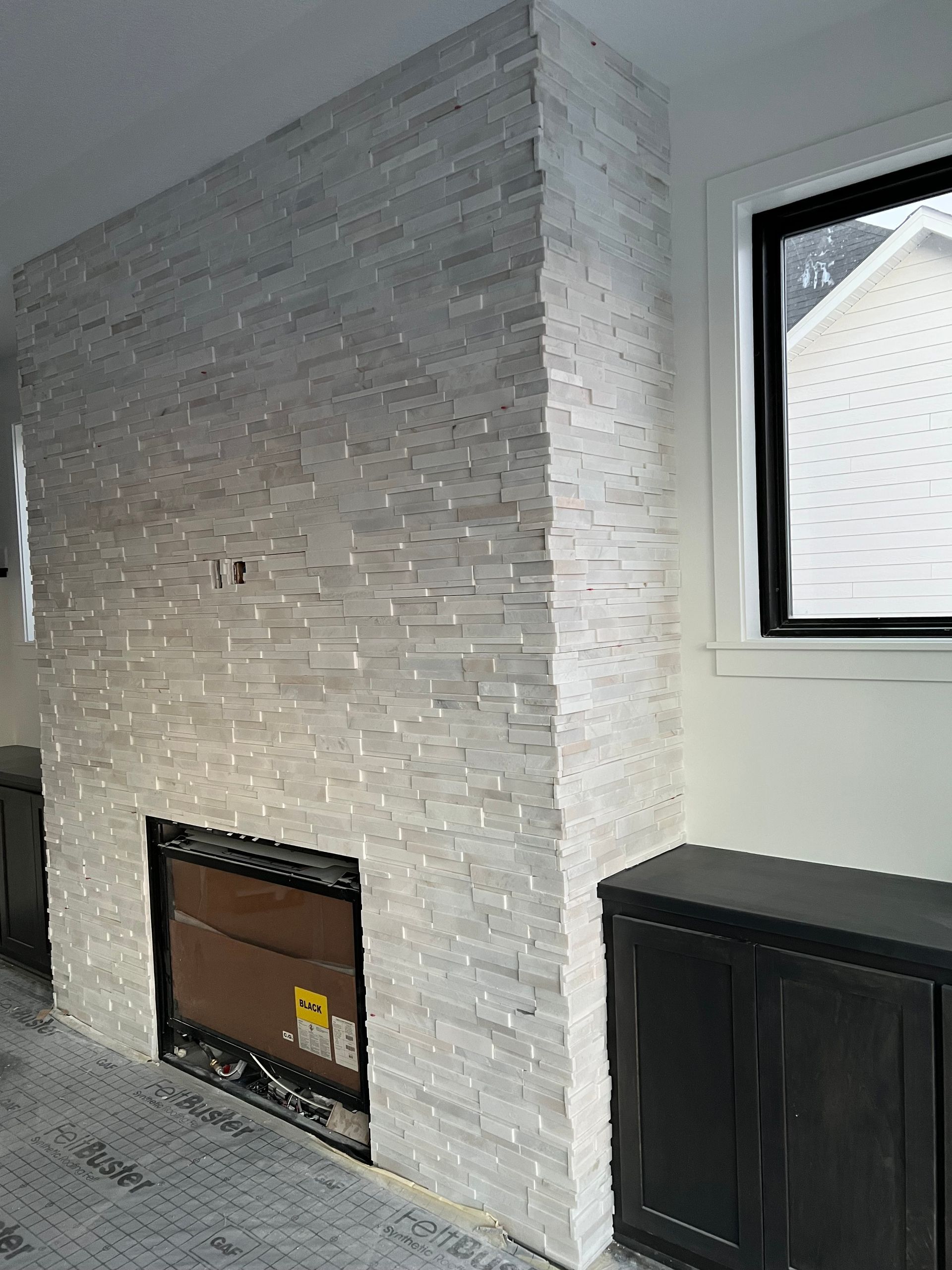 A living room with a fireplace and a window.