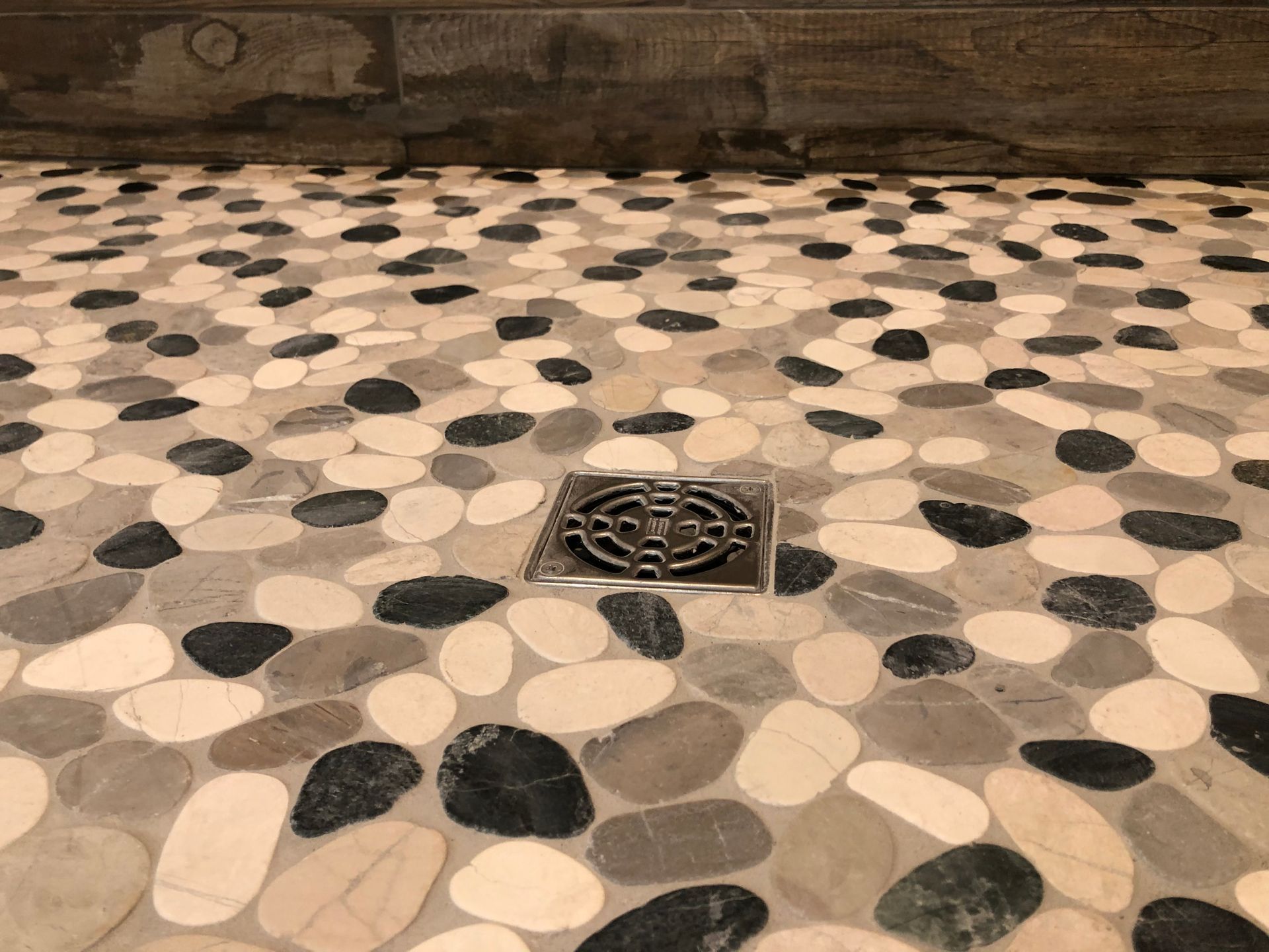 A shower floor with a drain in the middle of it