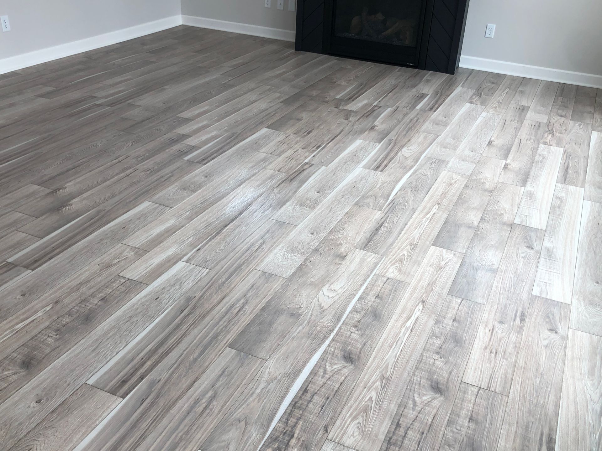 A living room with hardwood floors and a fireplace.