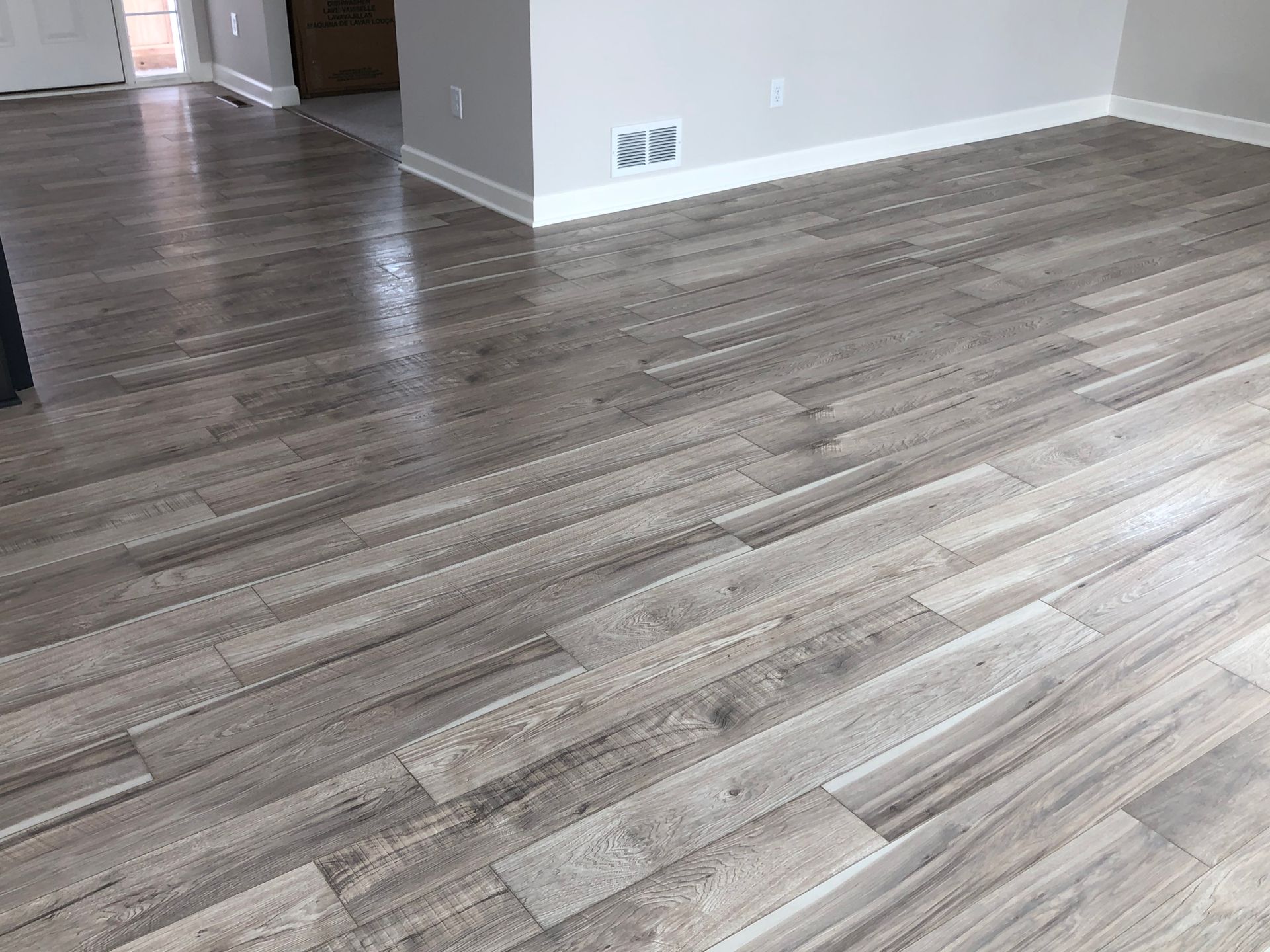 A living room with a wooden floor | BYN the Tile Crew