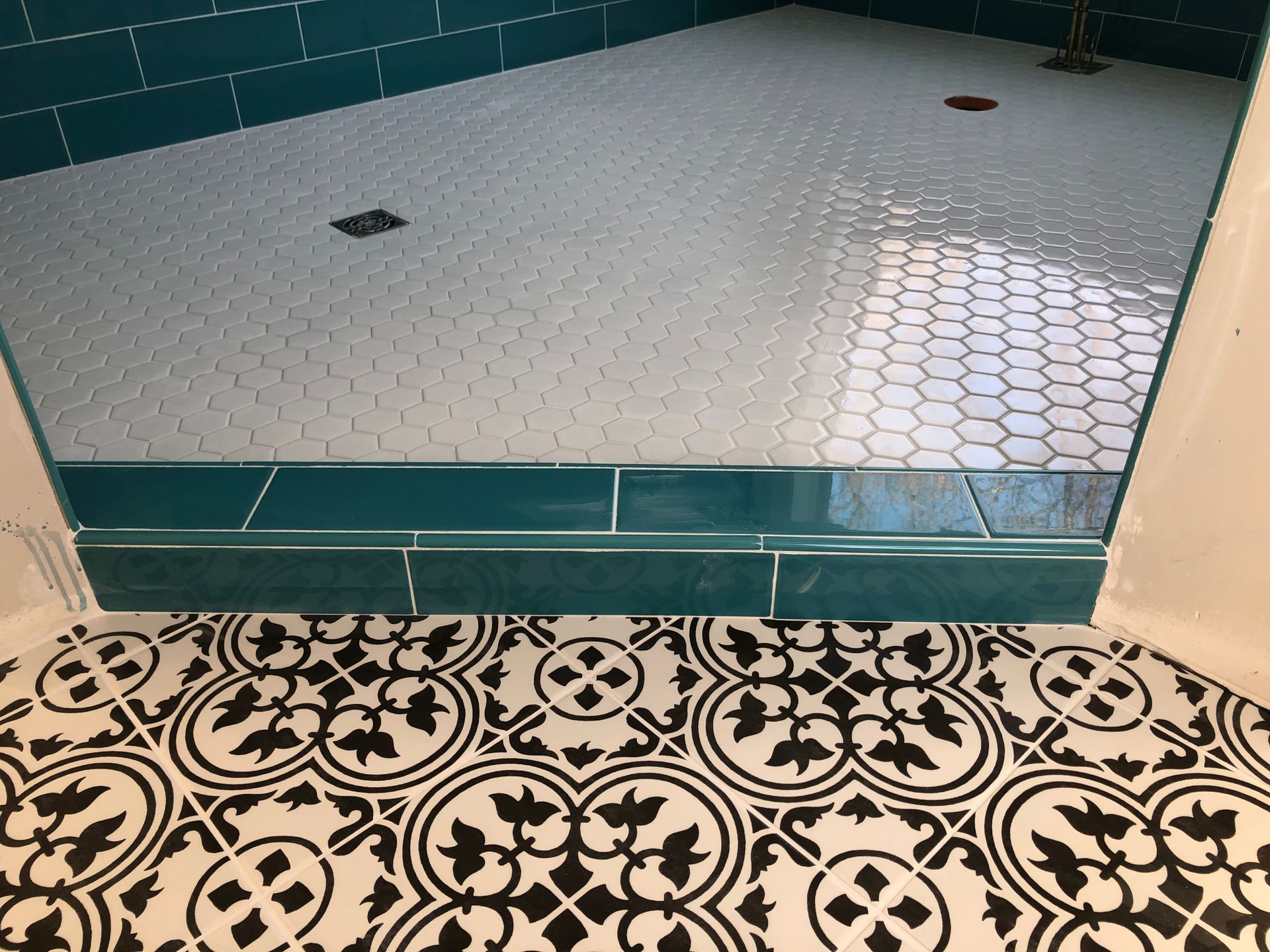 Custom tile work | A bathroom with a black and white tile floor