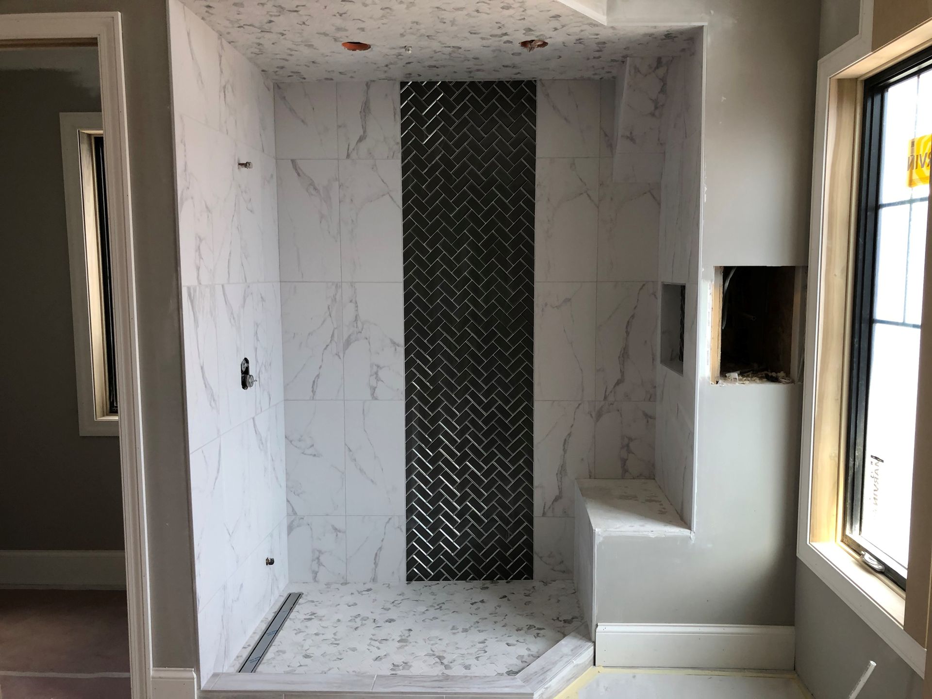 A bathroom with a walk in shower and a window.