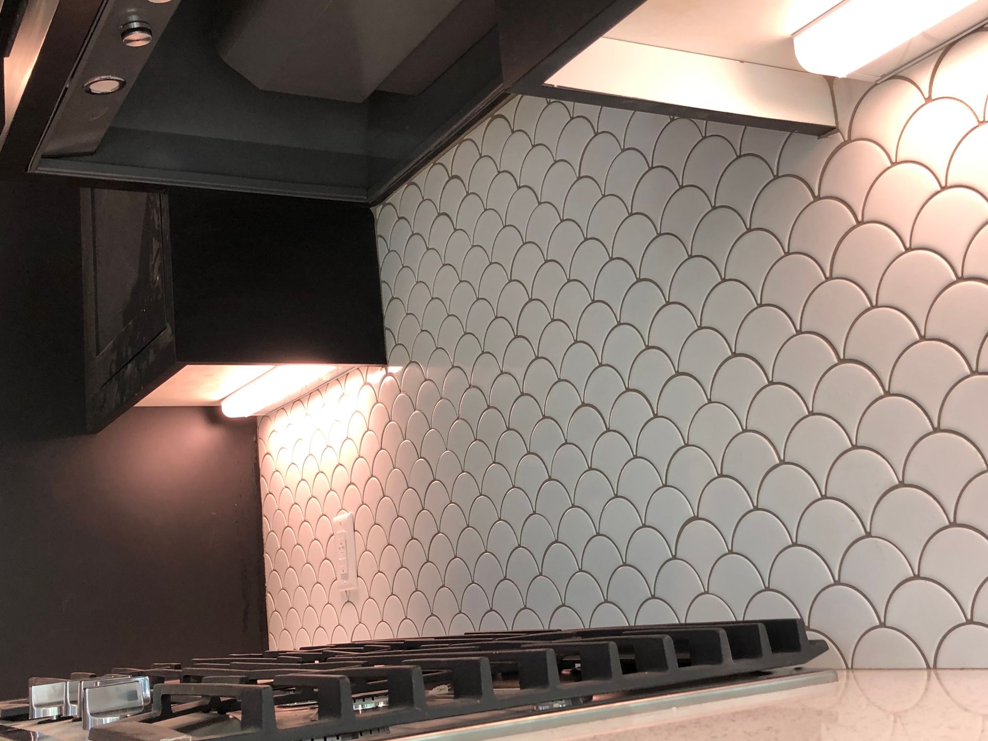 Beautiful backsplash | A kitchen with a stove top oven and a hood