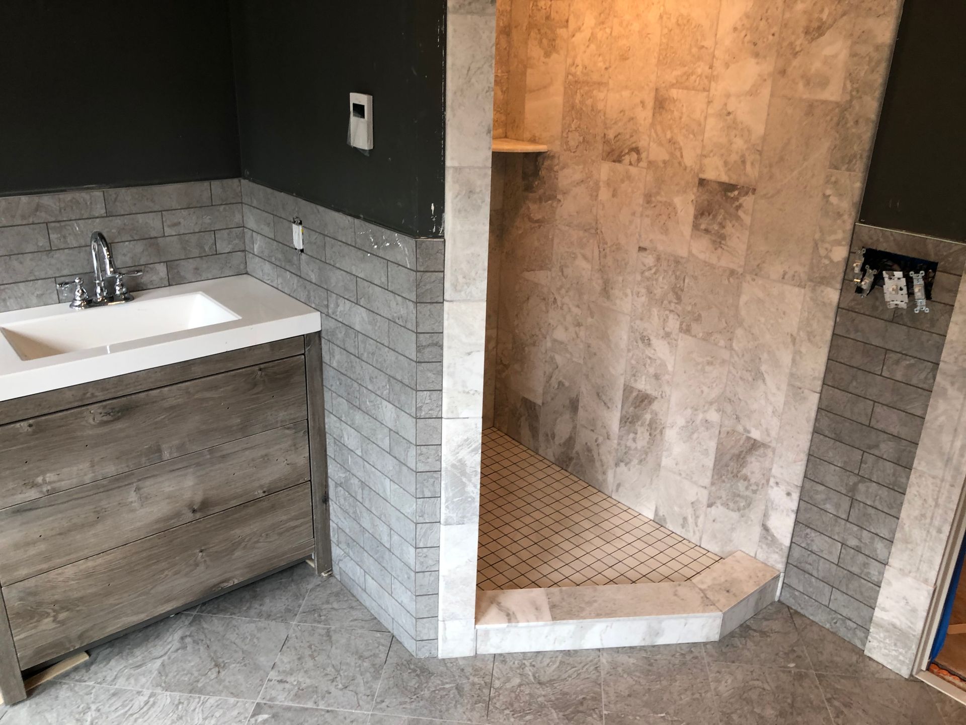 A bathroom with a sink and a walk in shower.