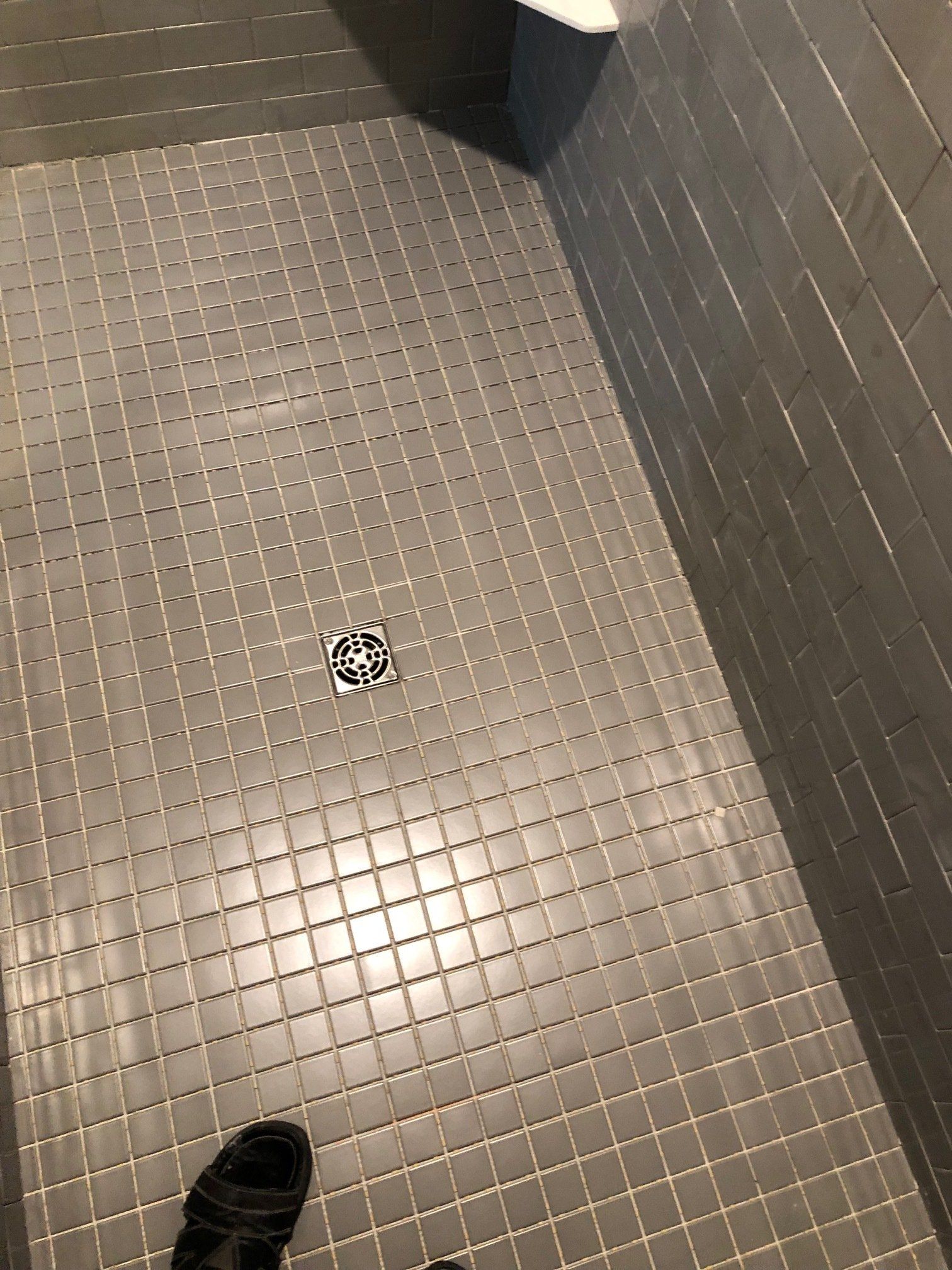 A person is standing on a tiled floor in a bathroom.