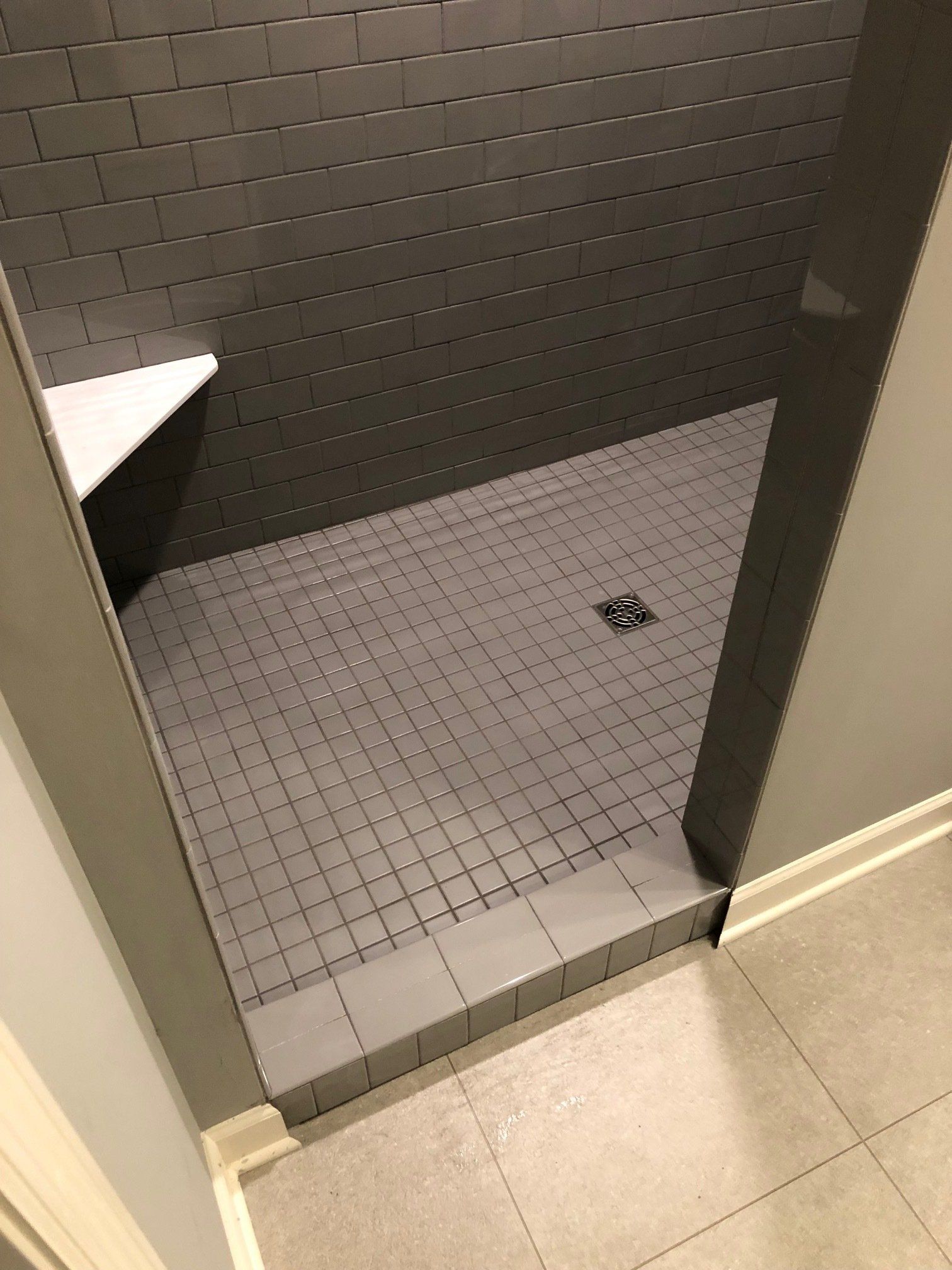 A bathroom with a walk in shower and a tiled floor.