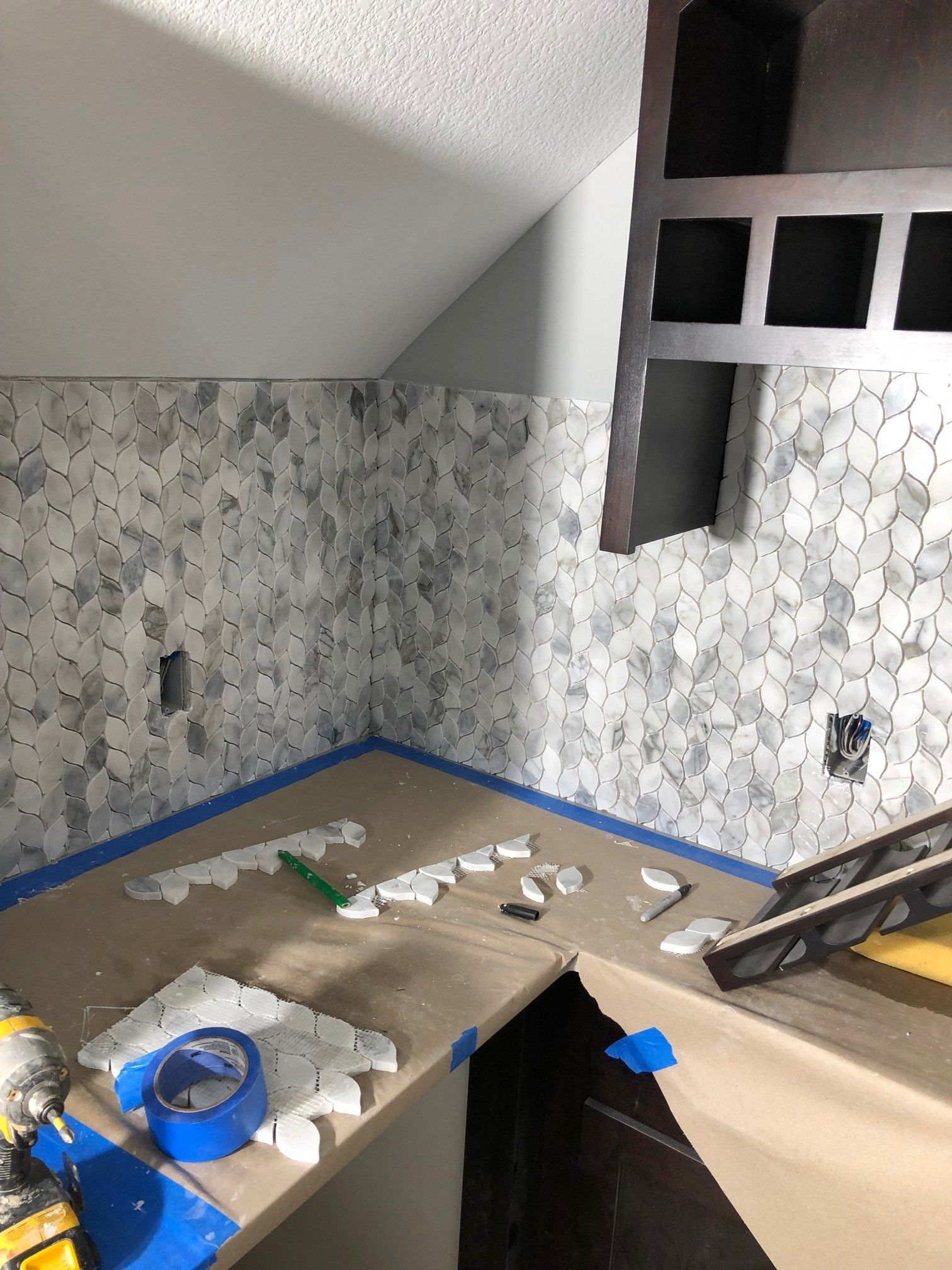 A kitchen is being remodeled and a blue tape is on the counter.