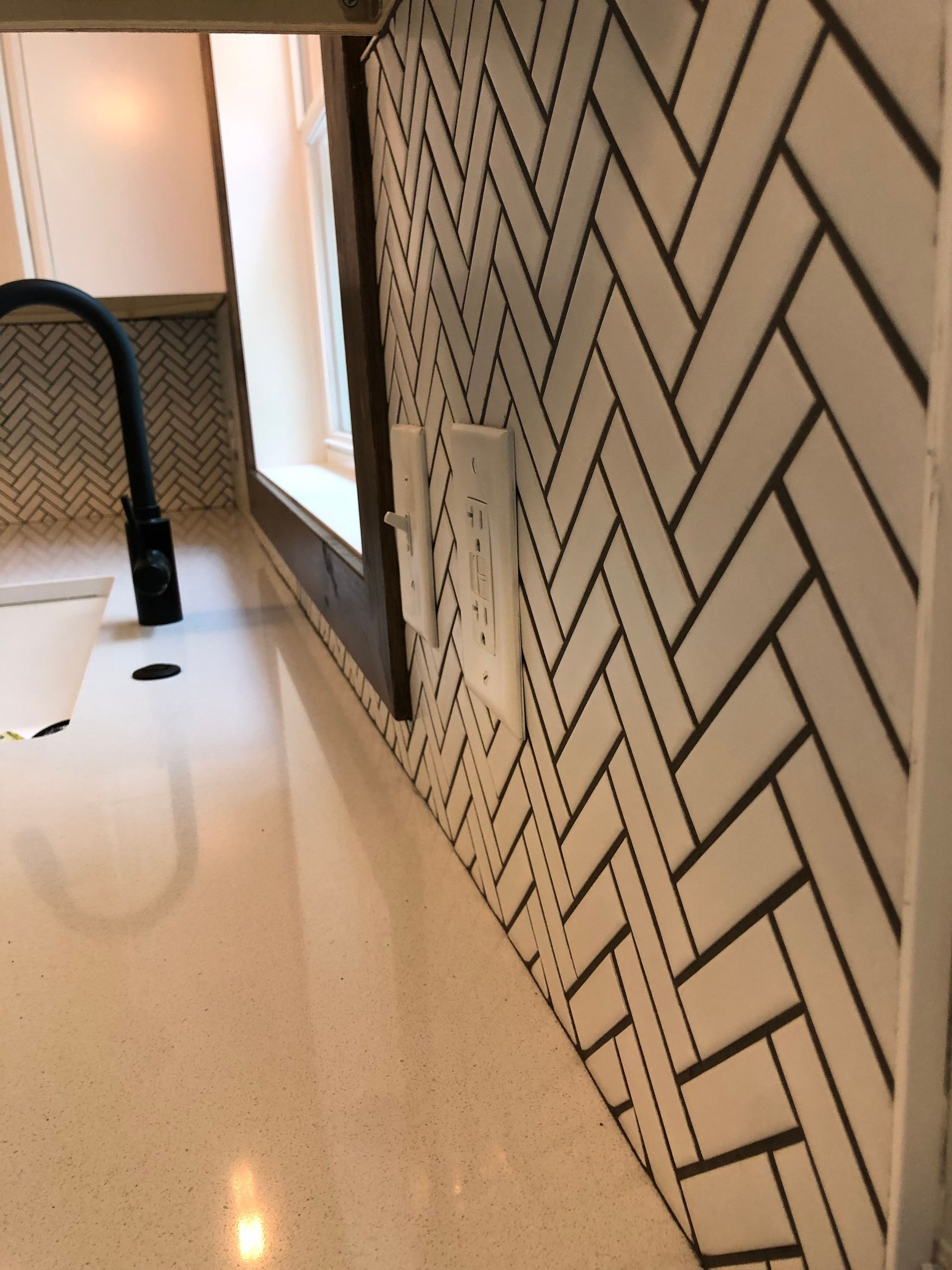 A kitchen with a herringbone pattern backsplash
