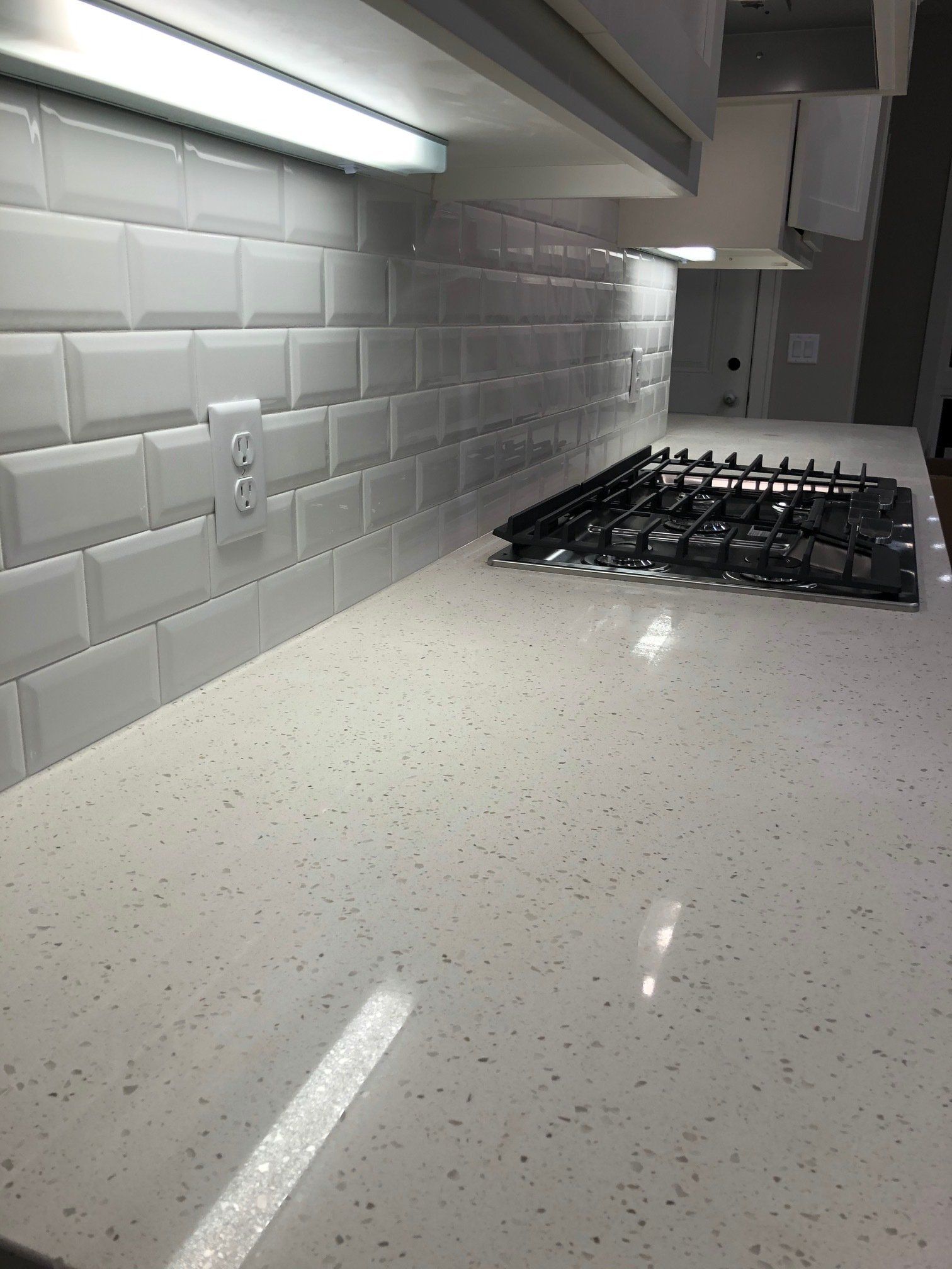 A kitchen with a stove top oven and a white counter top.