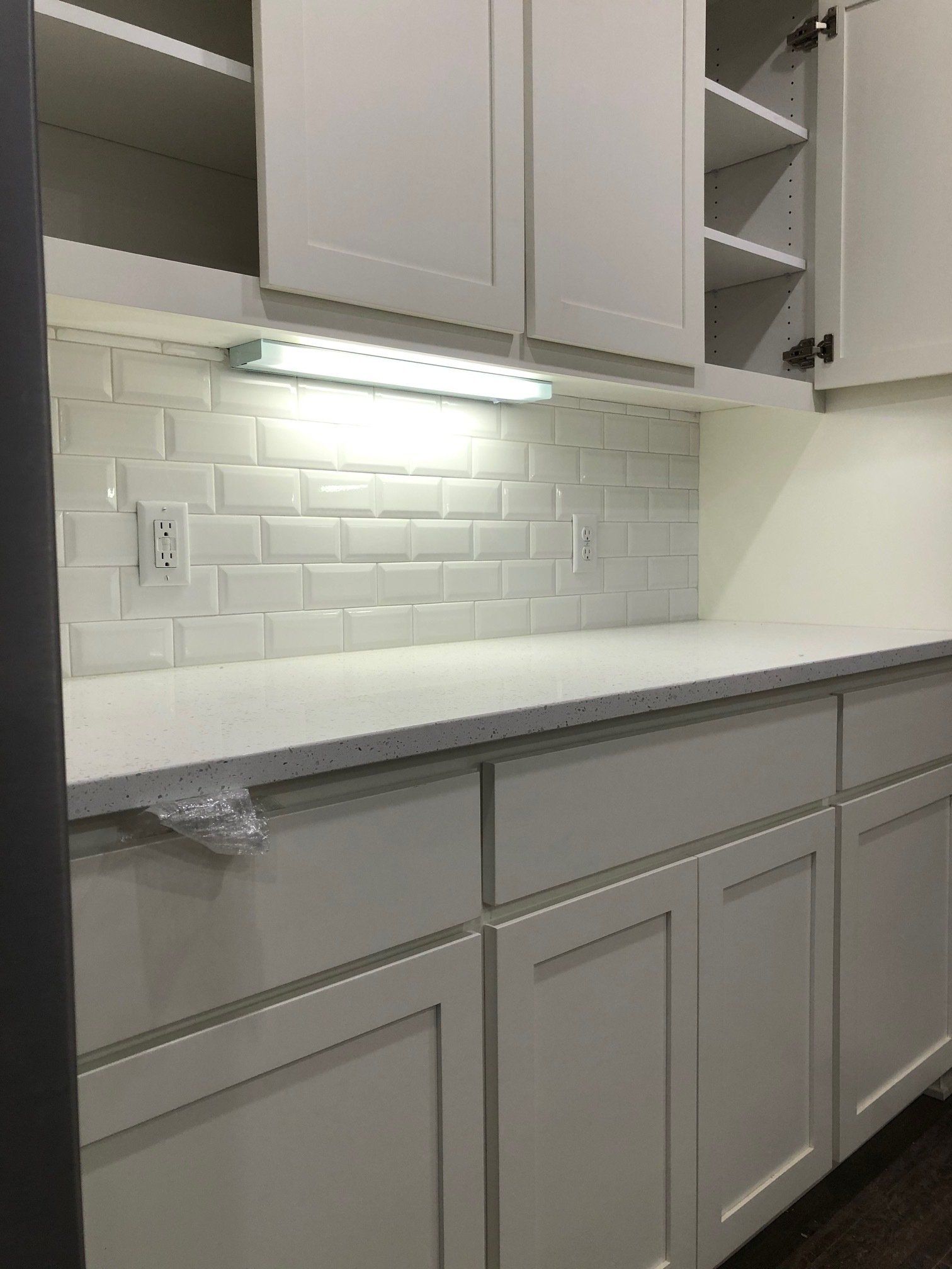 White backsplash | A kitchen with white cabinets and a subway tile wall.