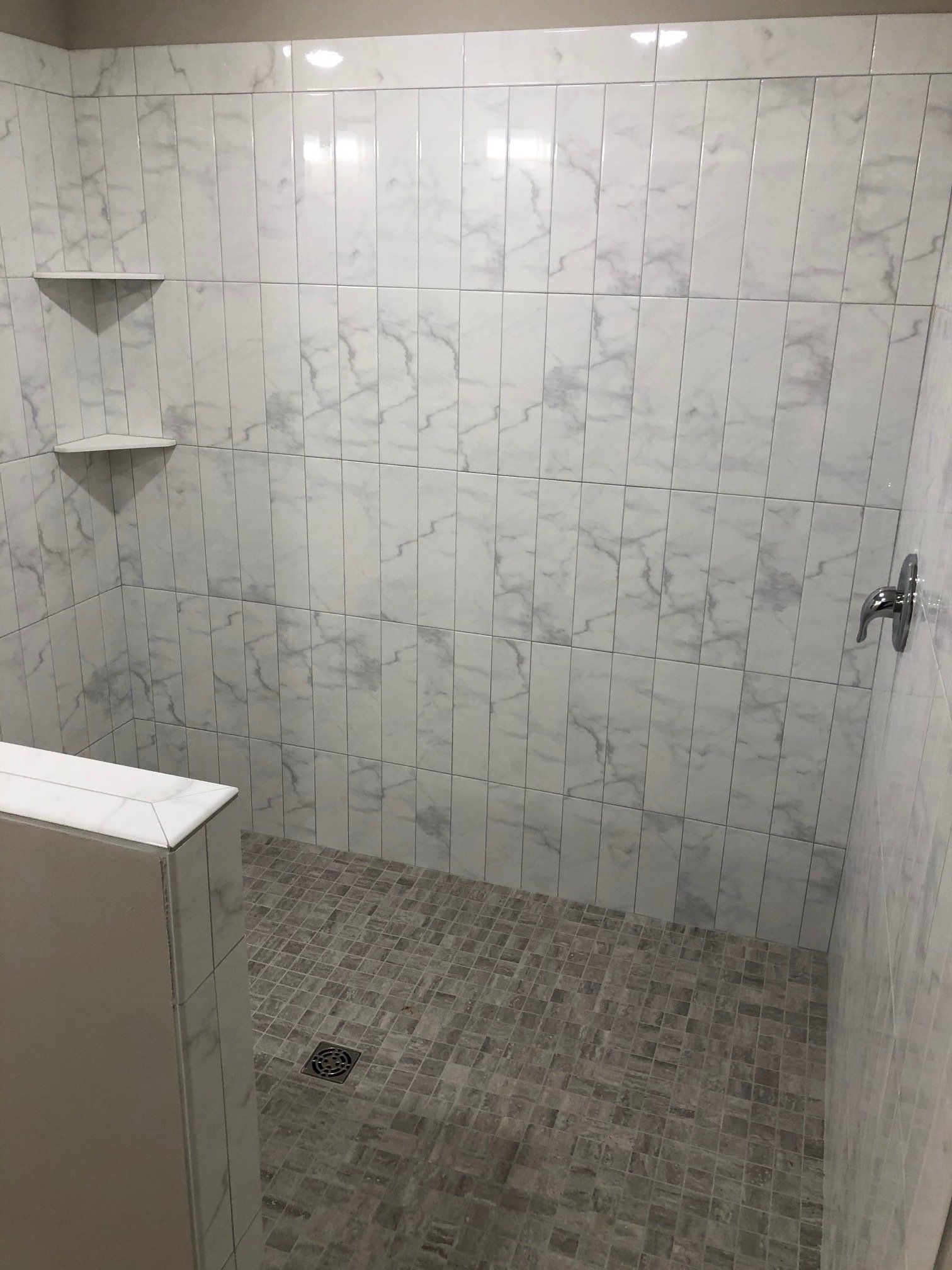 Bathtub to shower conversion | A walk in shower with marble tiles on the walls and floor.
