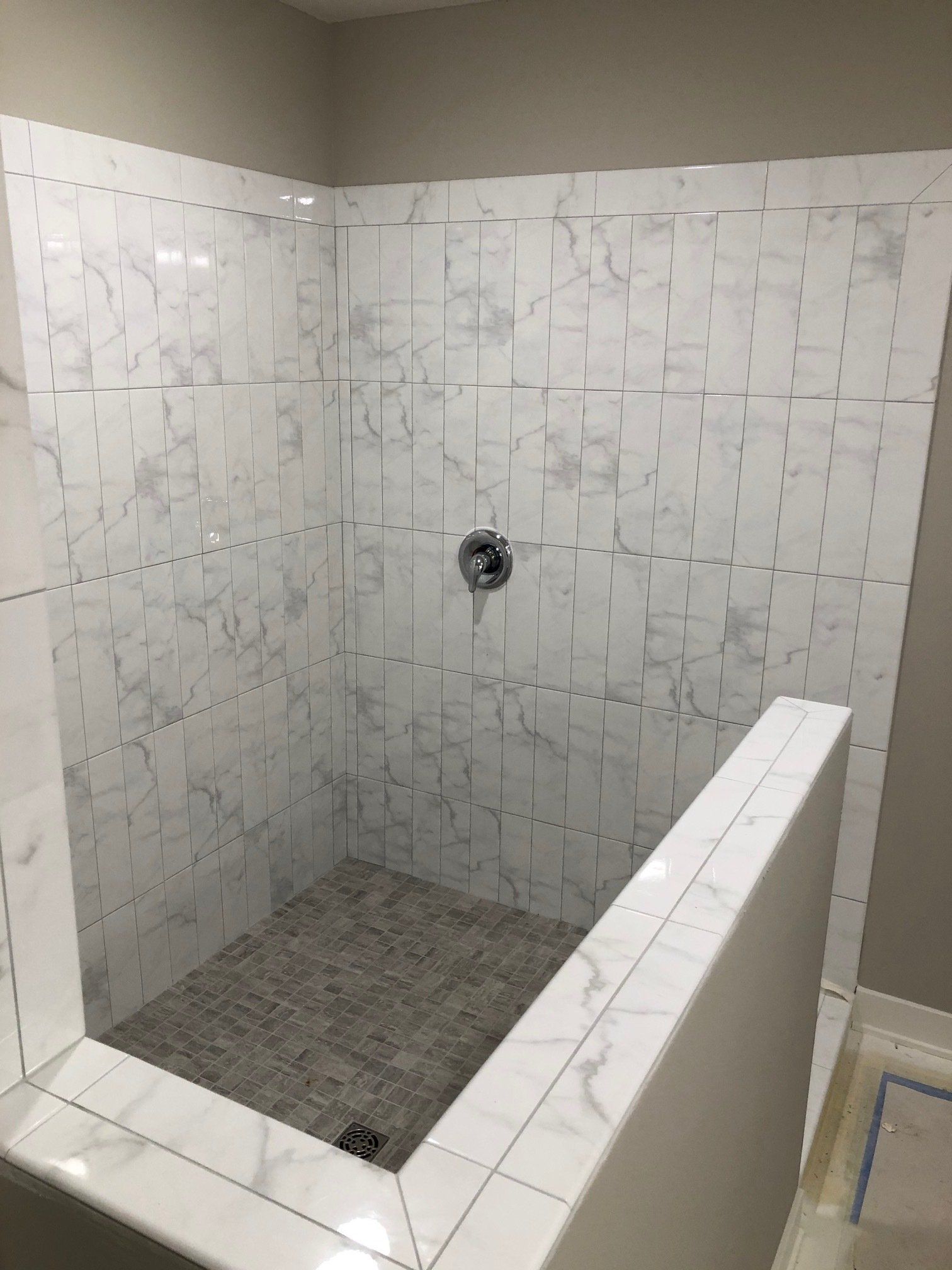 Bathtub to shower conversion | A bathroom with a walk in shower with white tiles on the wall.