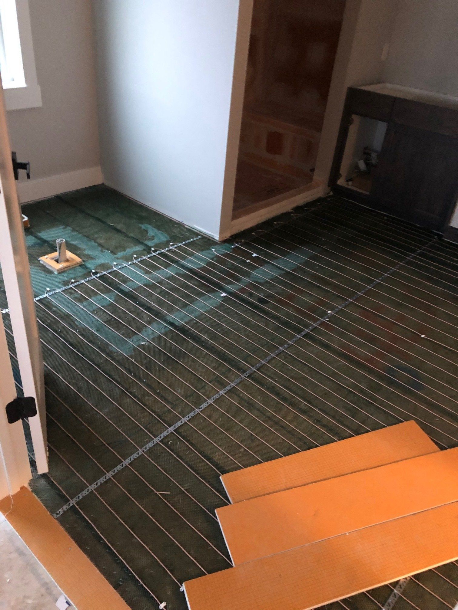 A room with a wooden floor and a green tile floor.