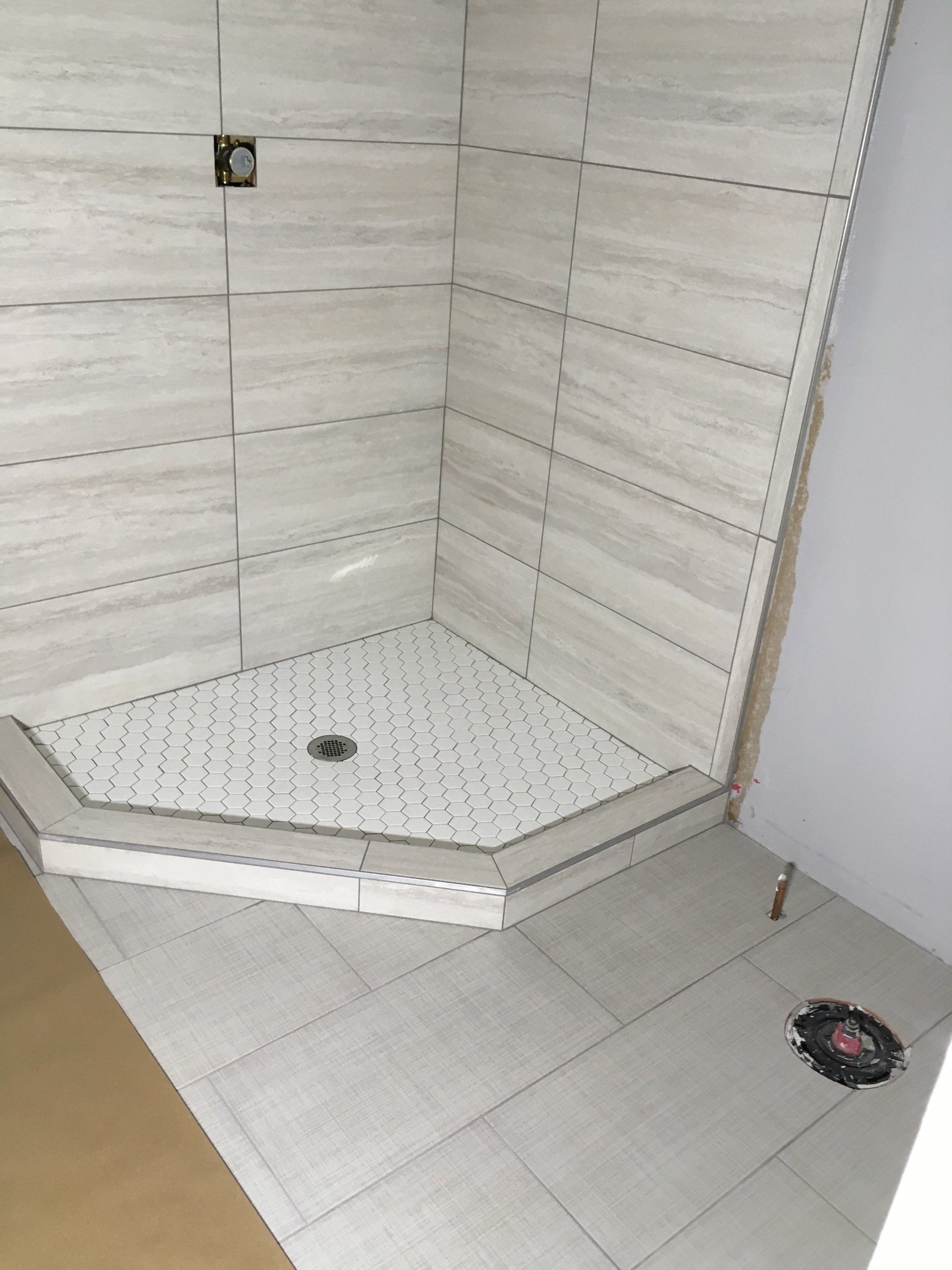 Shower upgrade | A shower stall is being built in a bathroom.