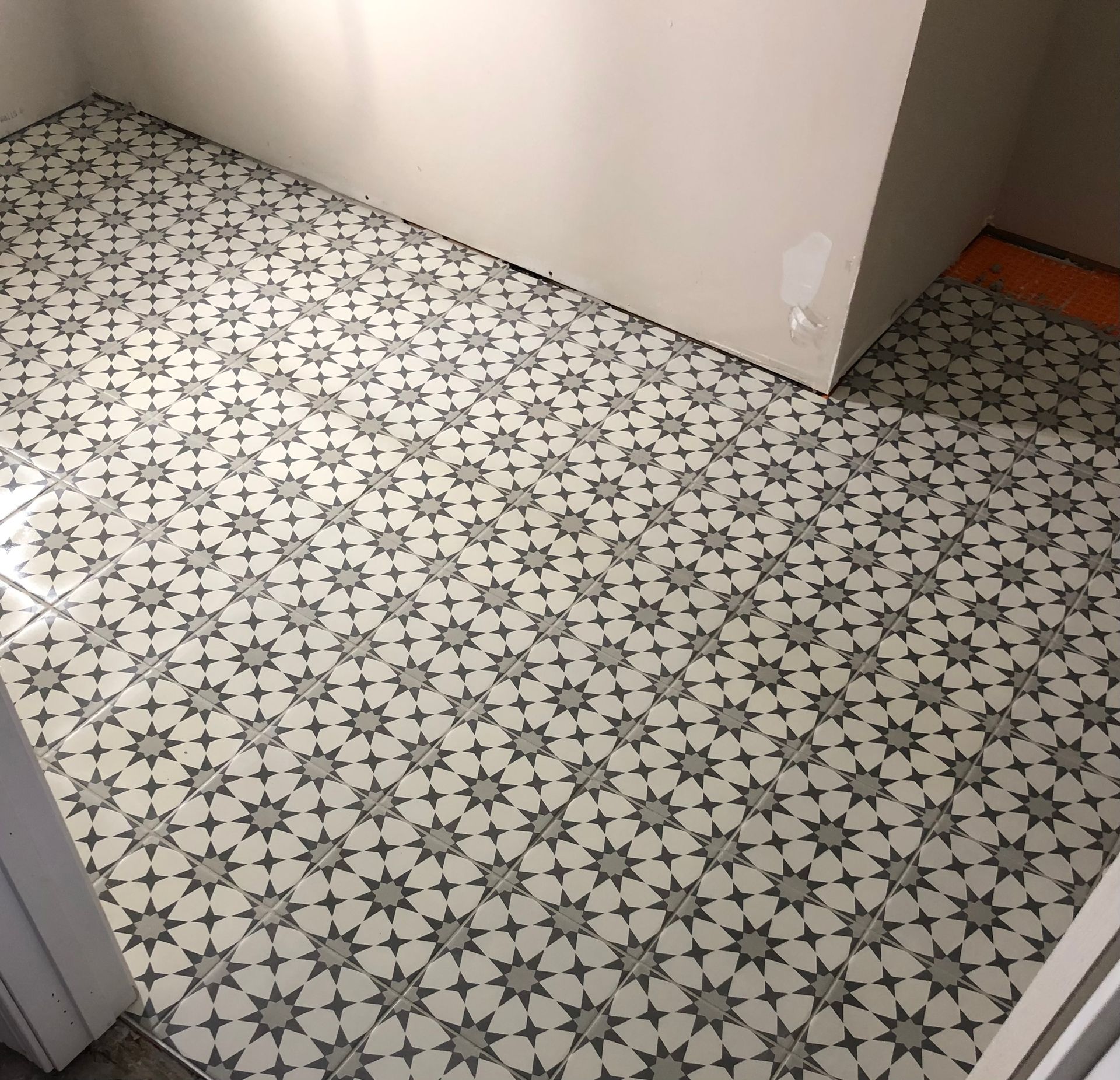 A tiled floor with a geometric pattern in a room.